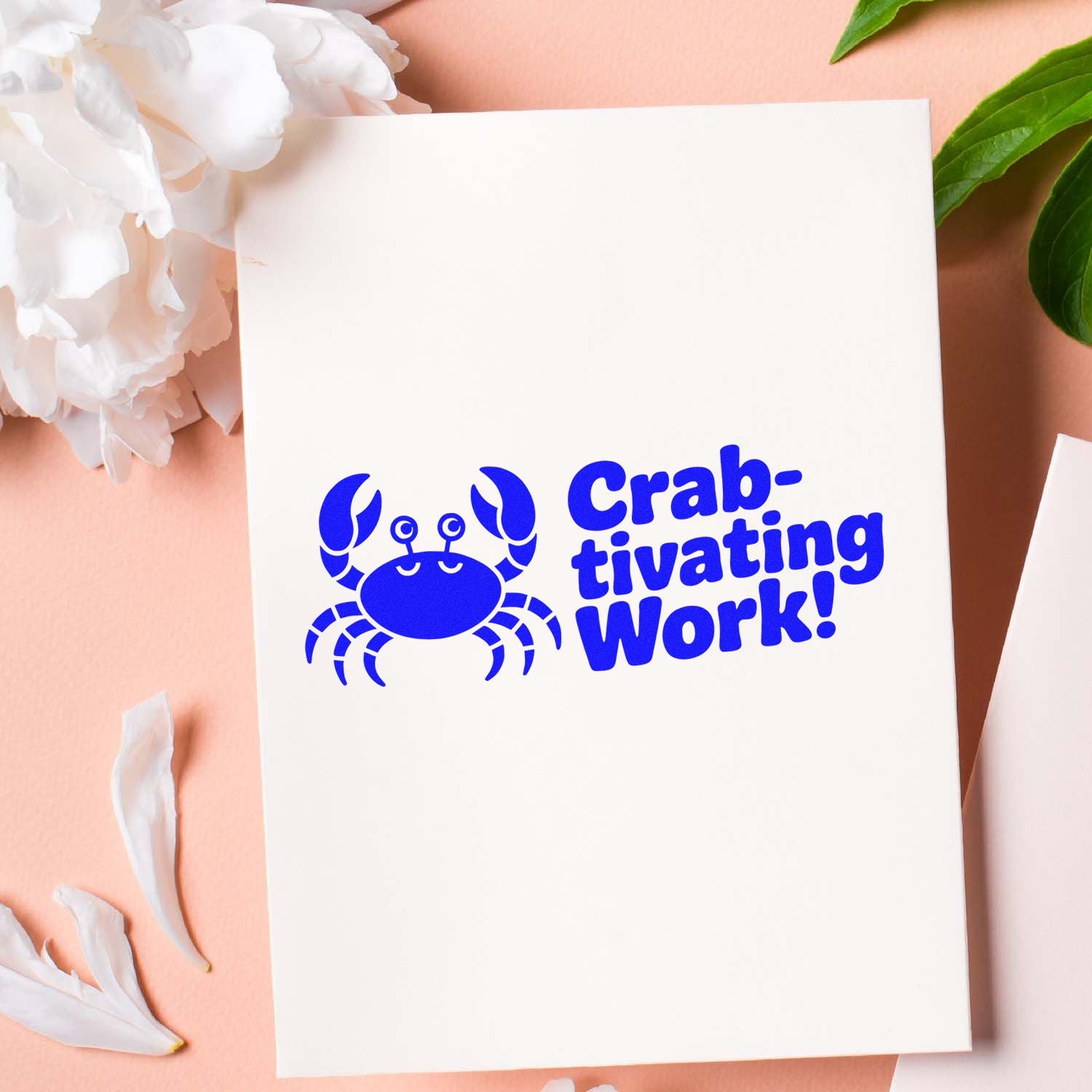 Cobalt blue crab Crab-tivating Work! stamp/seal on a white card, with peach background, white petals, and green leaves.