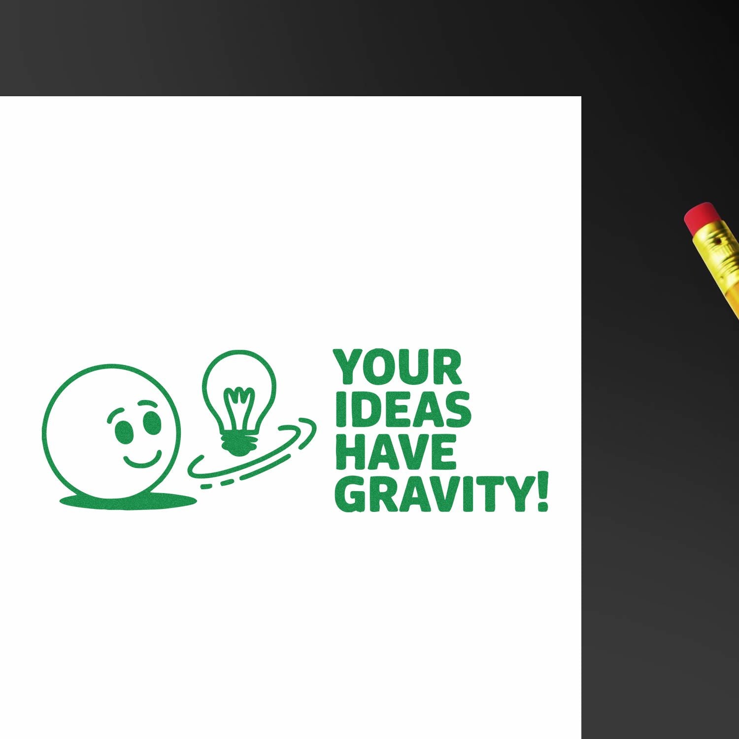 Green stamp and seal design with smiley face, lightbulb, and YOUR IDEAS HAVE GRAVITY! on white, pencil at right.