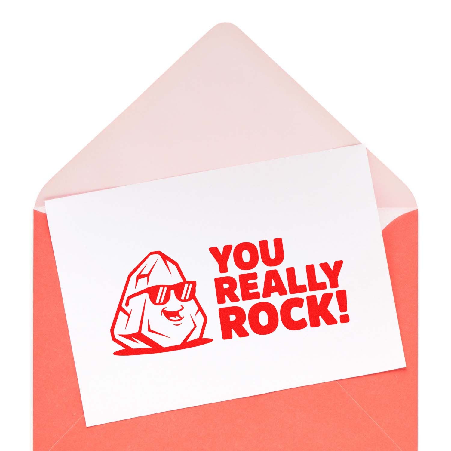 Red custom rubber stamp seal reading You Really Rock! with rock mascot on a white card in a pink envelope.