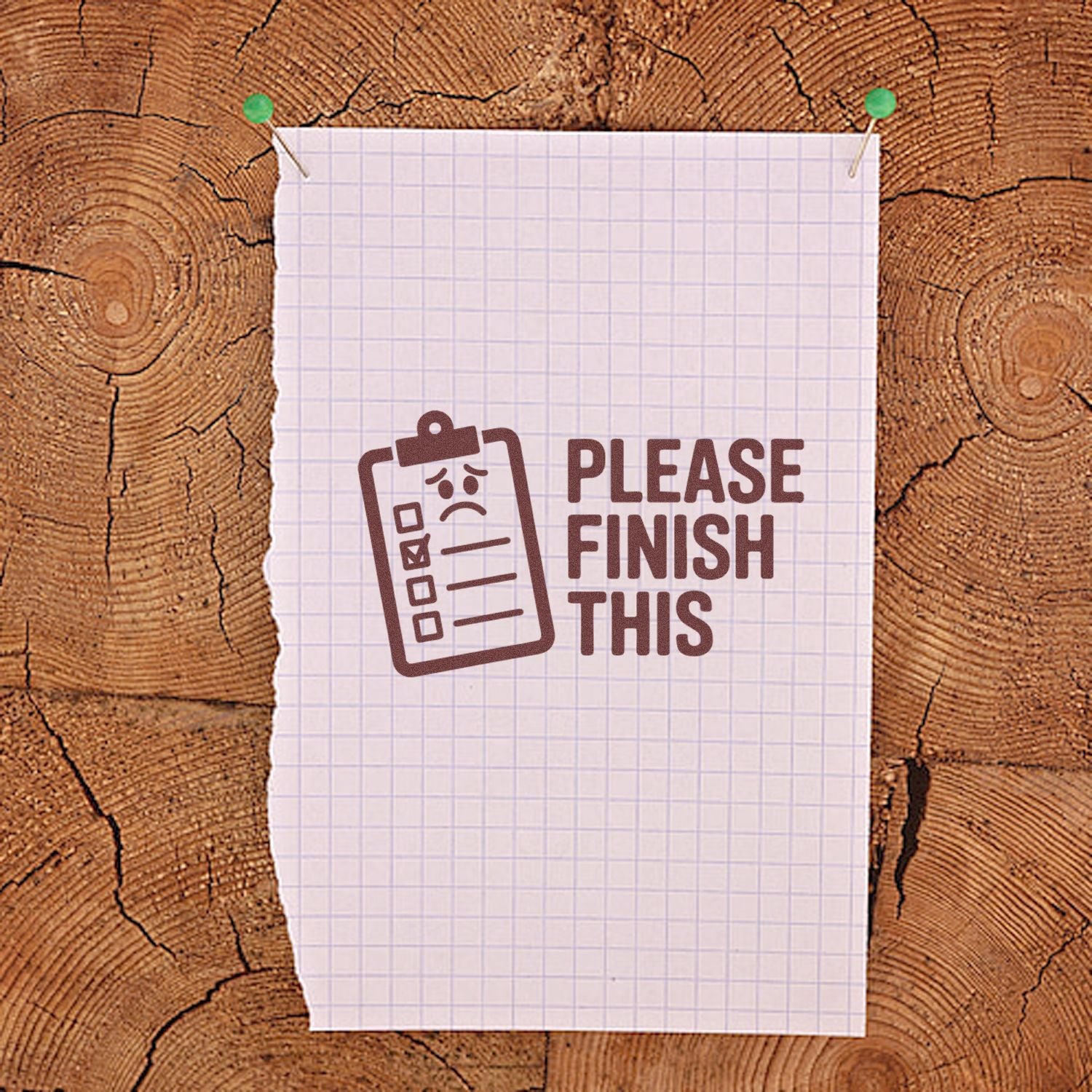 Brown clipboard stamp and seal reading Please Finish This on white graph paper, pinned to rustic wood with green tacks.