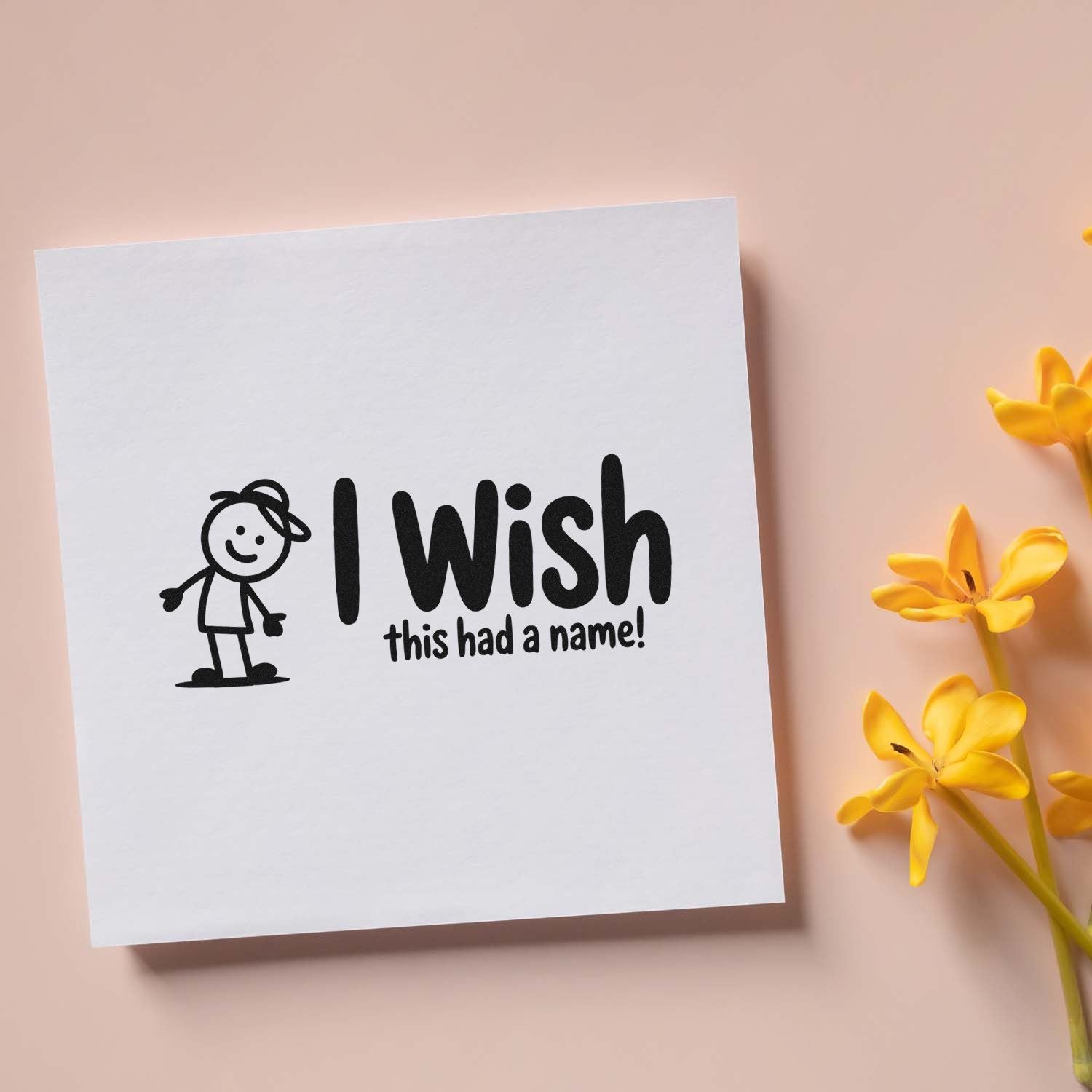 Black custom stamp and seal reading I wish this had a name! with a stick figure on a white card and yellow flowers.