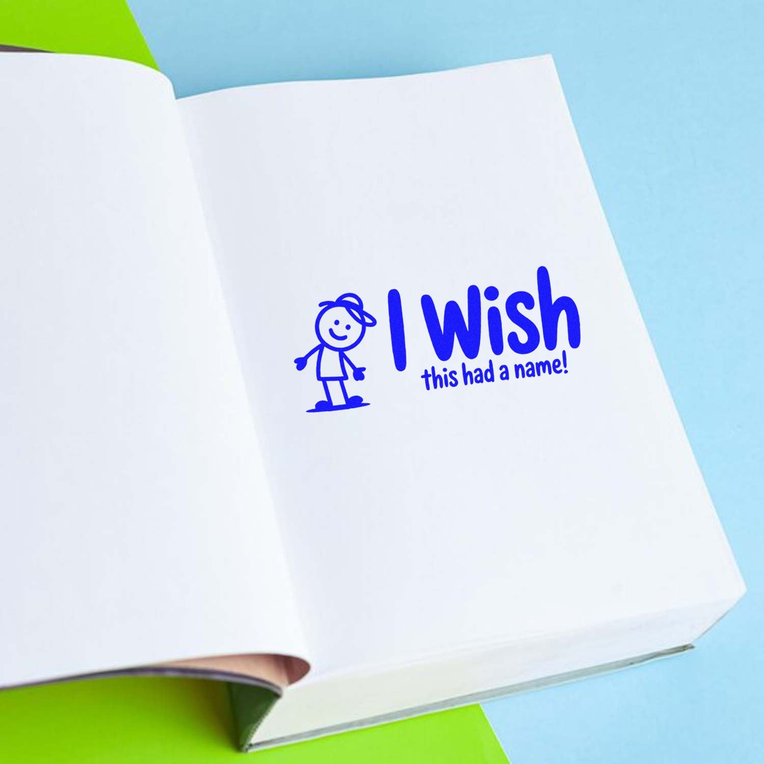 Open white book with blue stamp and seal reading I wish this had a name! plus cartoon figure on blue and lime background.