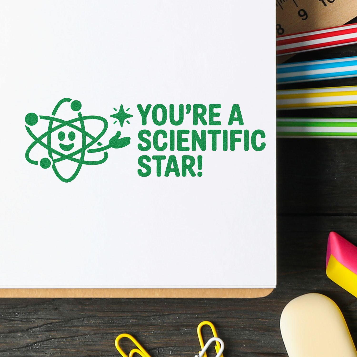 Green science atom stamp seal on white card reading Youre a Scientific Star! beside colorful stamp ink pads.