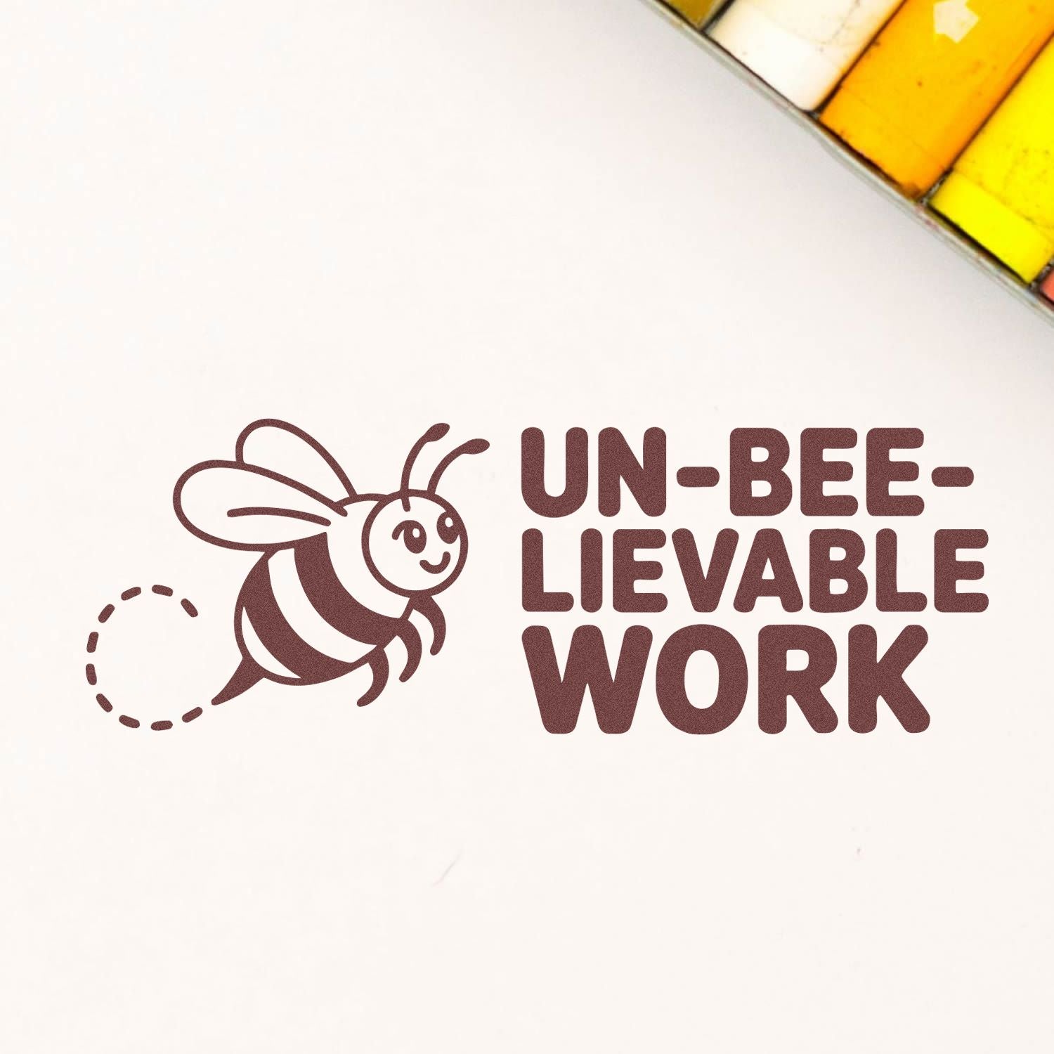 Bee-themed rubber stamp and seal reading UN-BEE-LIEVABLE WORK, with yellow stamp pads in the corner.