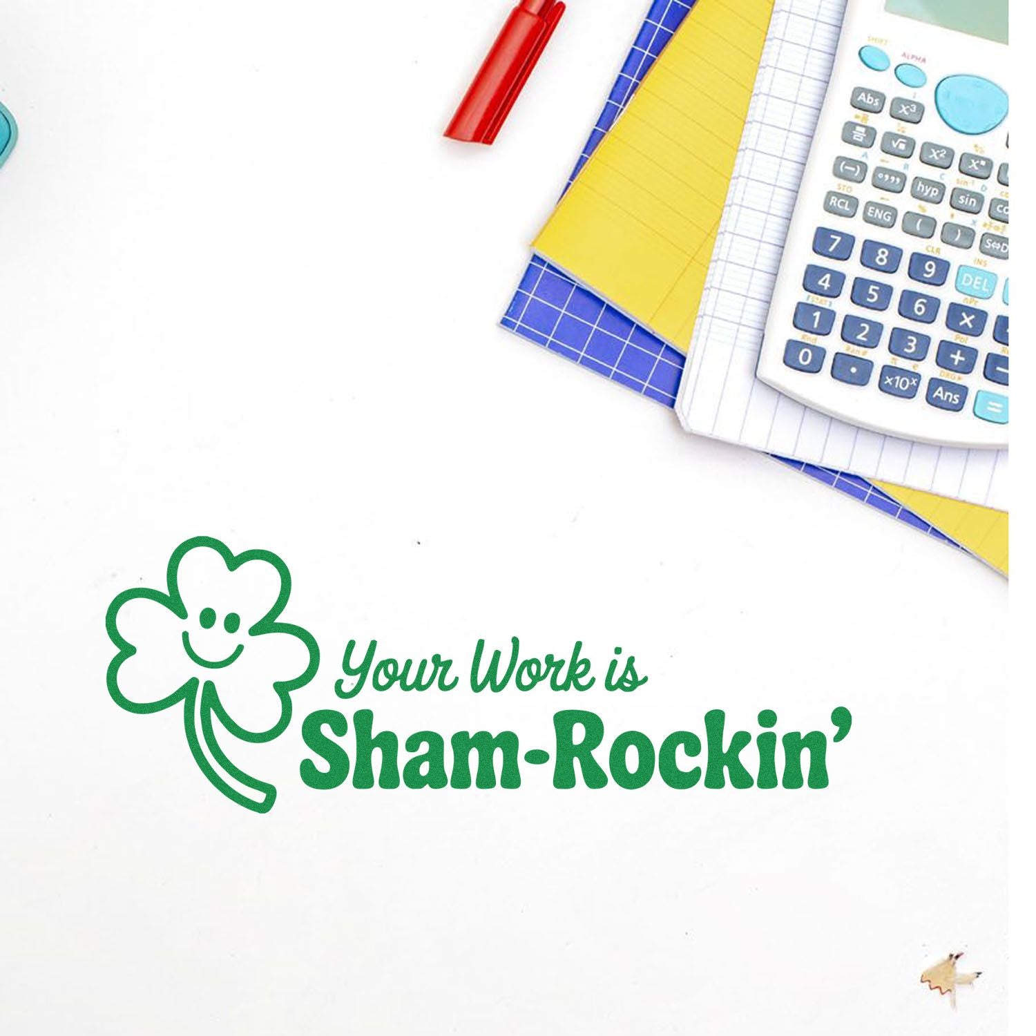 Green shamrock stamp and seal reading Your Work is Sham-Rockin with calculator, notebooks, and red pen.