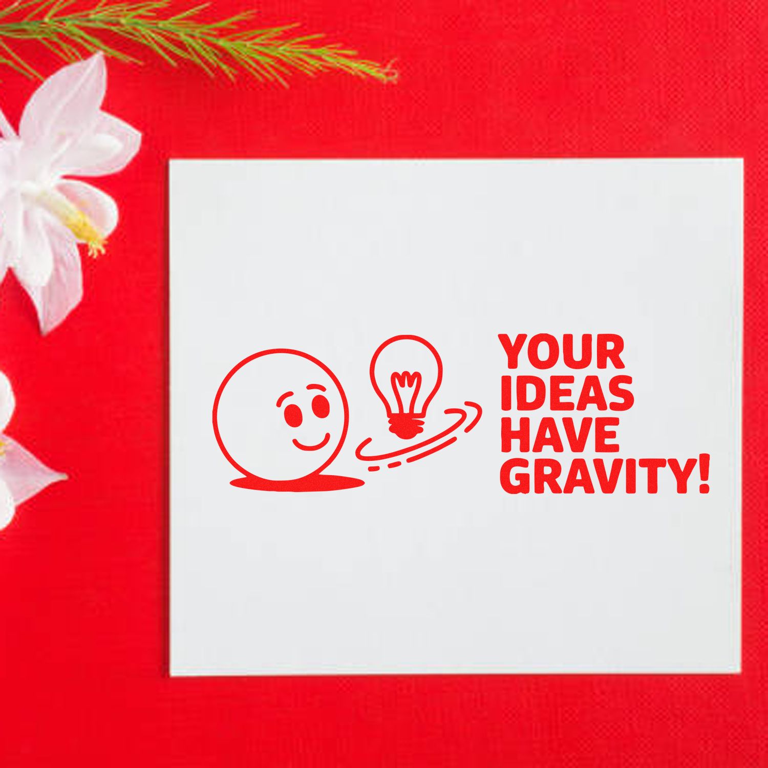 Custom red stamp and seal on white square, with smiley face, lightbulb, and Your Ideas Have Gravity! on red background.