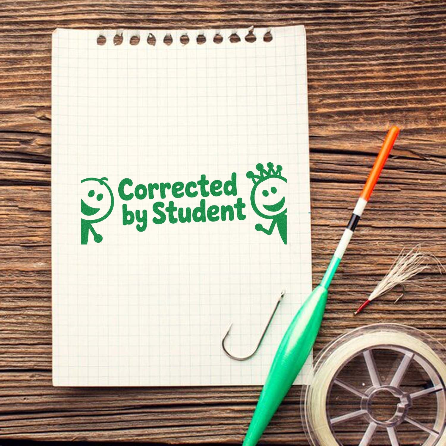 Green Corrected by Student stamp on graph paper notebook with school supplies and tape