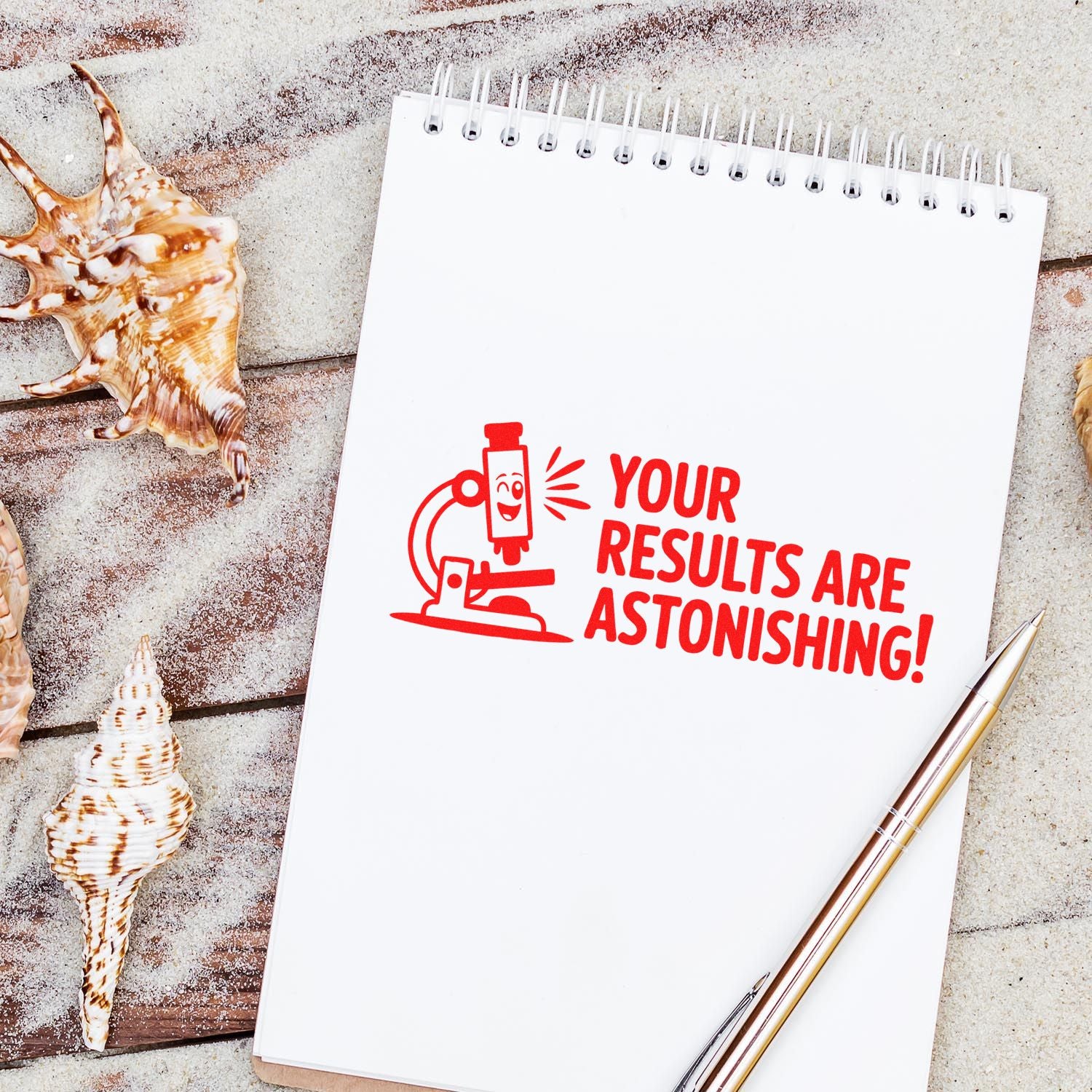 Red stamp-and-seal design on white spiral notebook: Your results are astonishing! with microscope icon, seashells, and pen.