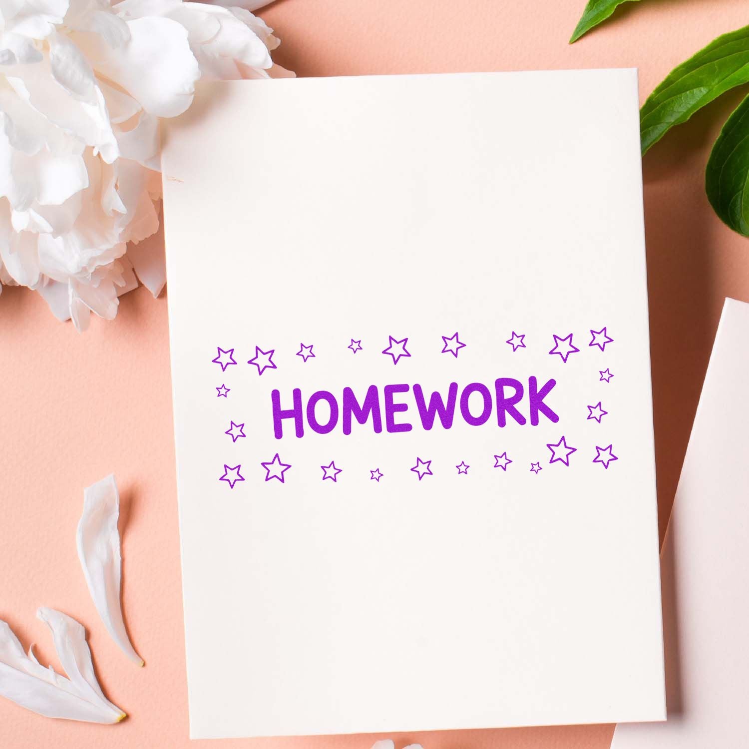 Purple HOMEWORK stamp with star seal on white card, styled on a pink background with white flowers and green leaves.