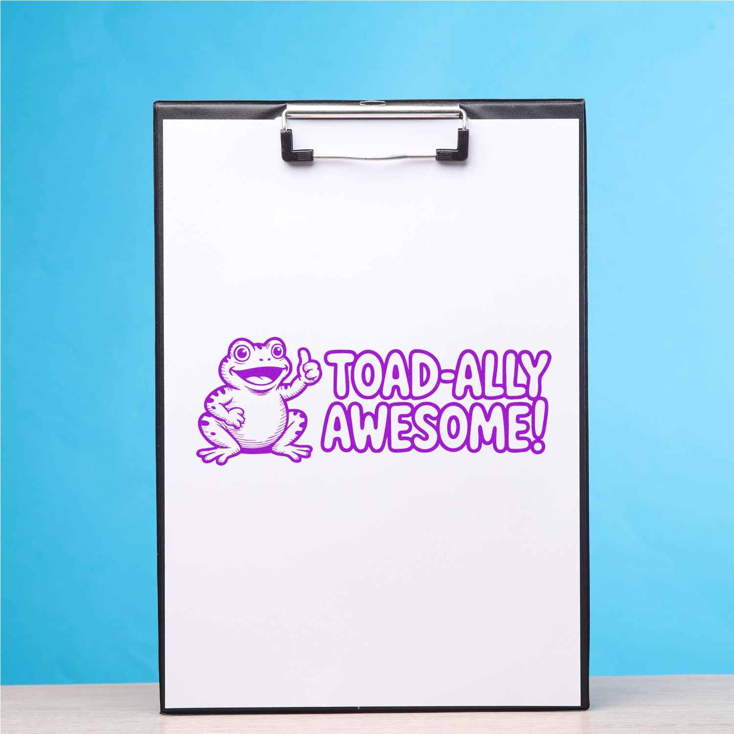 White clipboard with purple frog TOAD-ALLY AWESOME! stamp and seal design on blue background.
