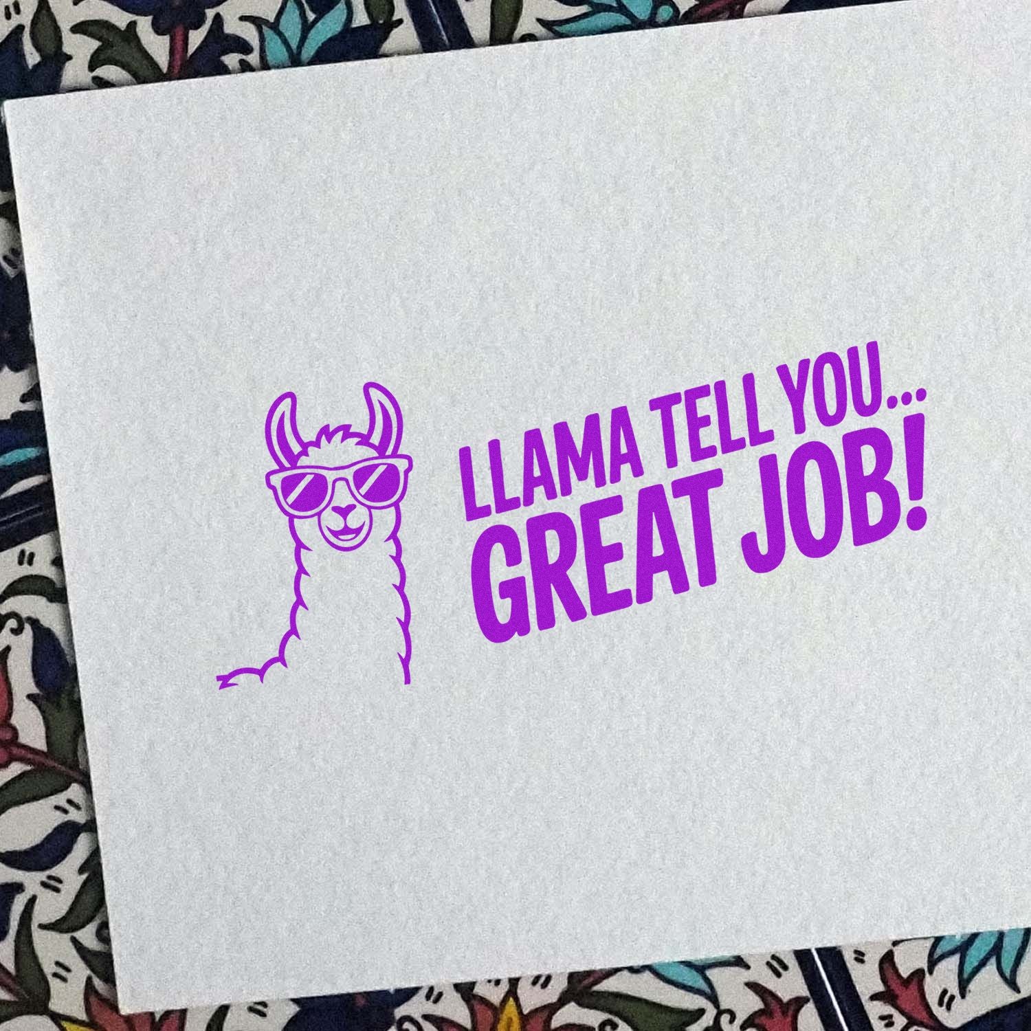 Purple stamp seal with a llama in sunglasses and the text LLAMA TELL YOU... GREAT JOB! on white paper.