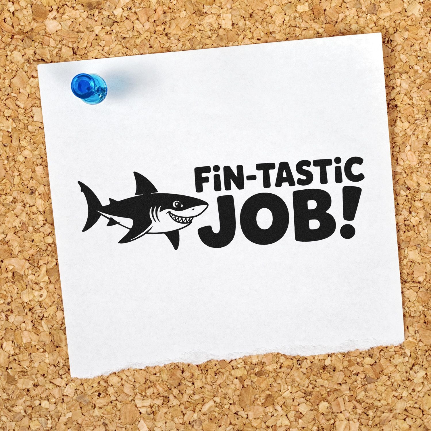 Blue-pinned white paper with black shark stamp seal reading FIN-TASTIC JOB! on corkboard