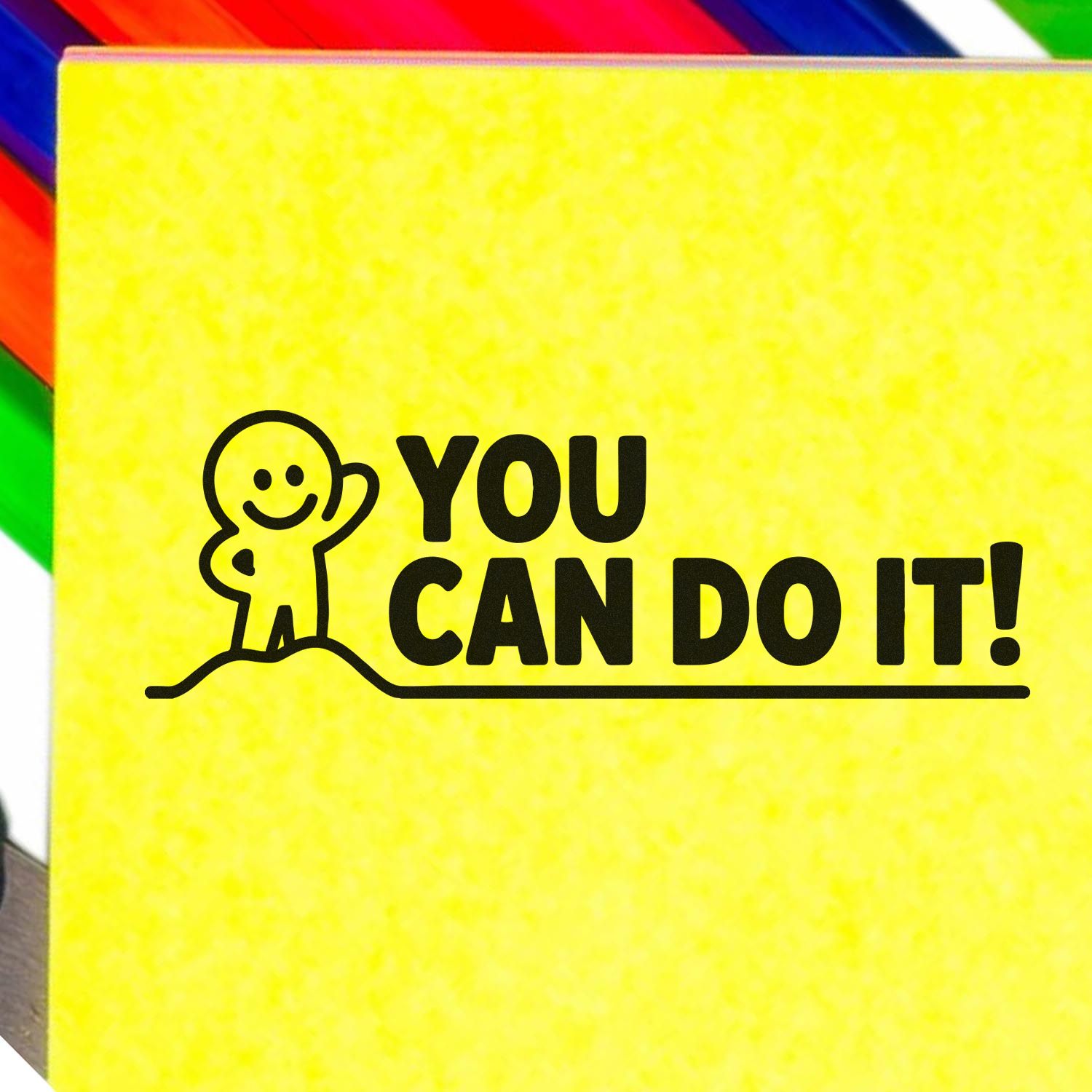 Yellow motivational stamp seal with black You Can Do It! text and smiling figure on a rainbow-colored background.