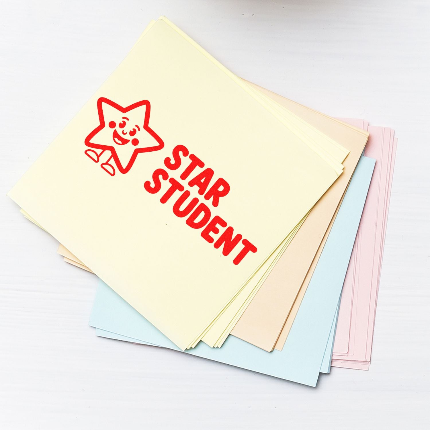 Pastel stamp and seal papers stacked, featuring a red STAR STUDENT stamp on a cream sheet.