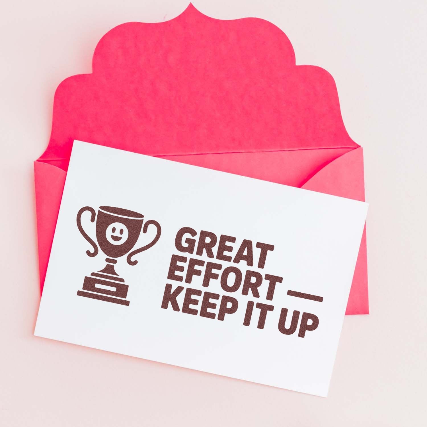 Pink envelope with a white reward stamp card, brown trophy seal, and Great Effort Keep It Up message.