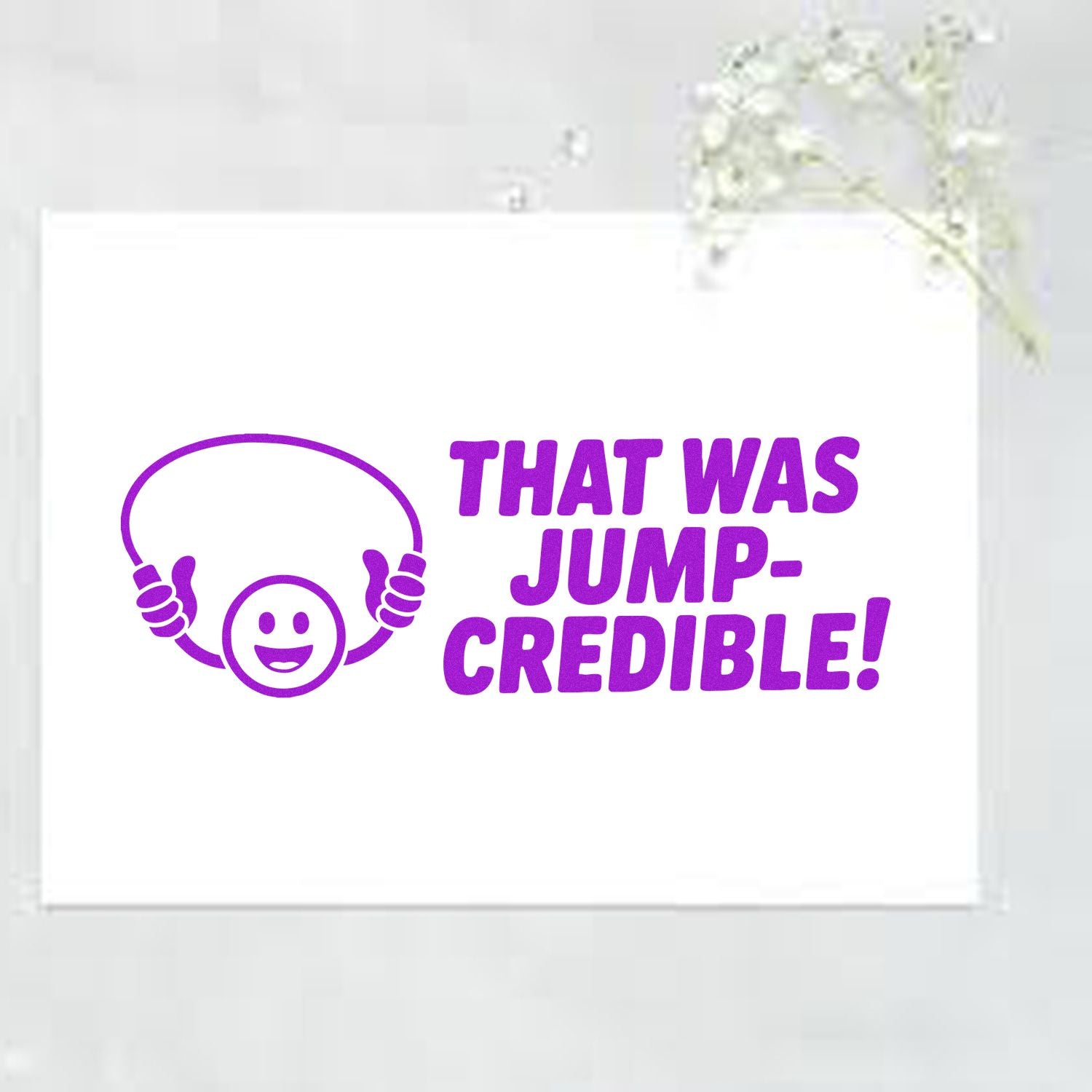 Purple self-inking stamp and seal with smiley face and THAT WAS JUMP-CREDIBLE! in bold purple on white paper.