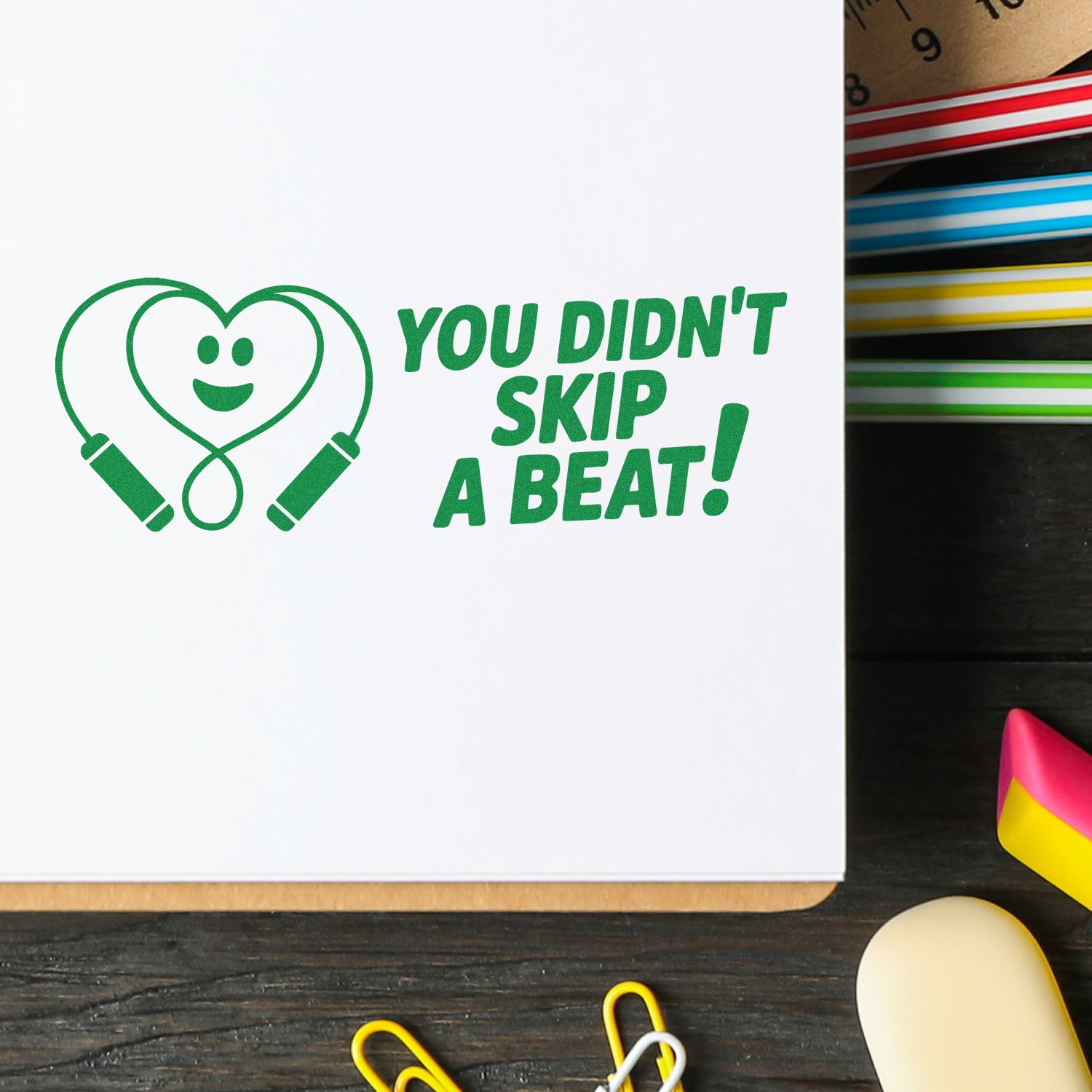 Green stamp-and-seal design with heart stethoscope and You didnt skip a beat! on white, beside colorful ink pads.