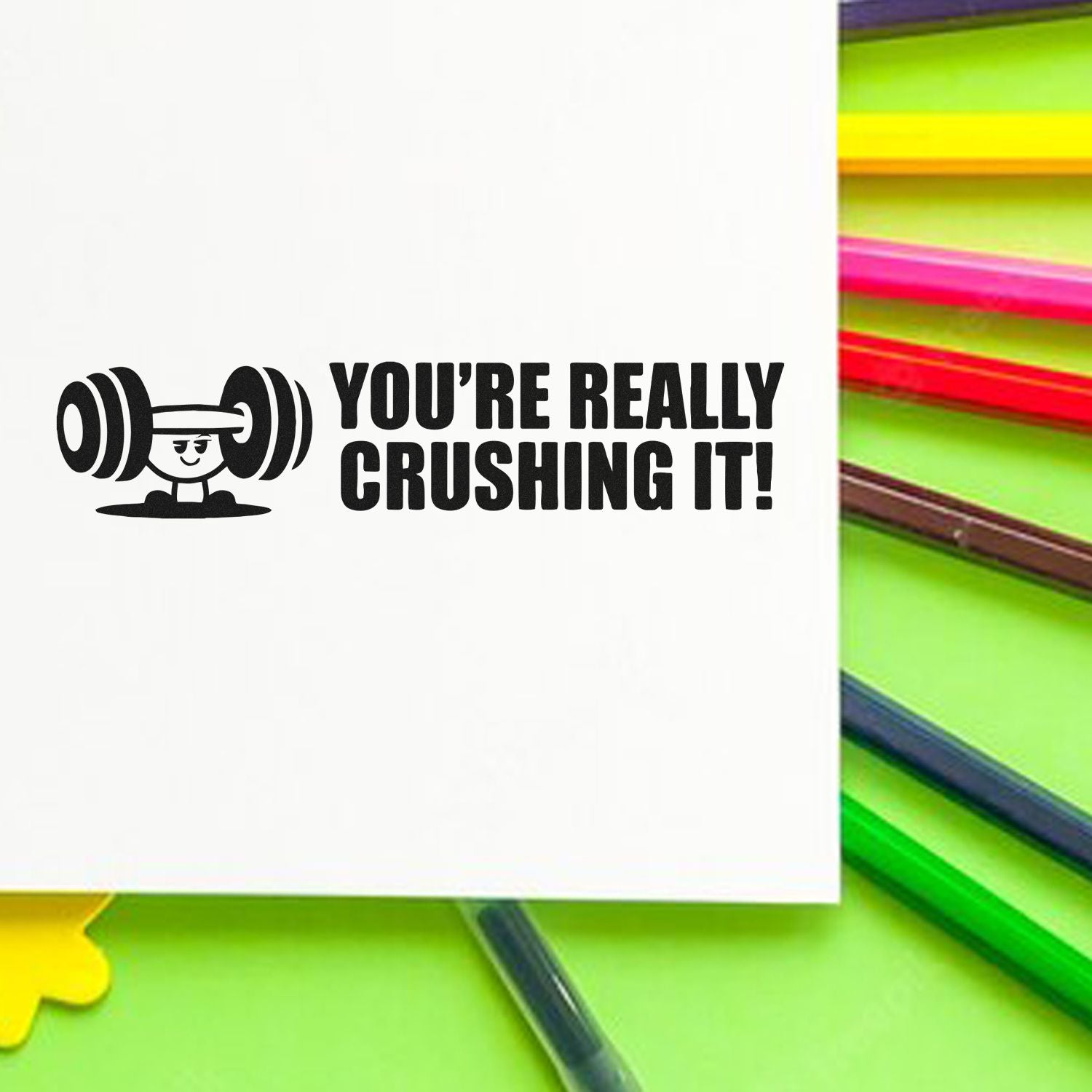 Black motivational stamp reading Youre really crushing it! with weightlifter icon, beside bright neon seal products.