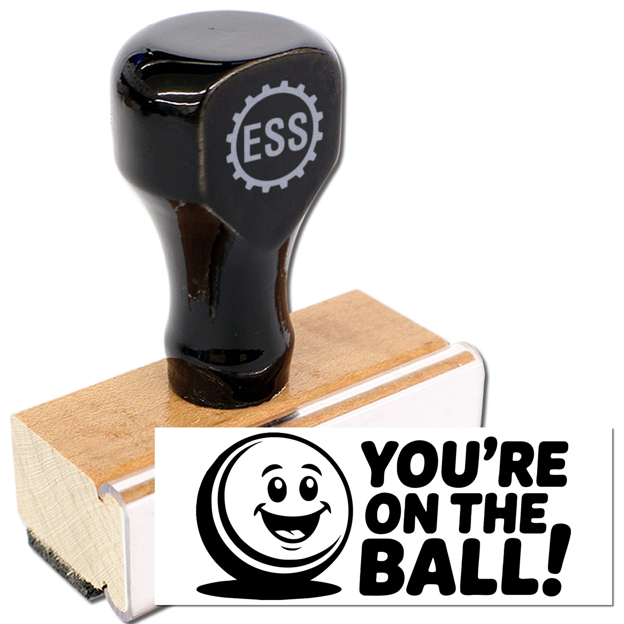 Black ESS rubber stamp and seal on wooden block, with smiley logo and bold Youre on the Ball! text.