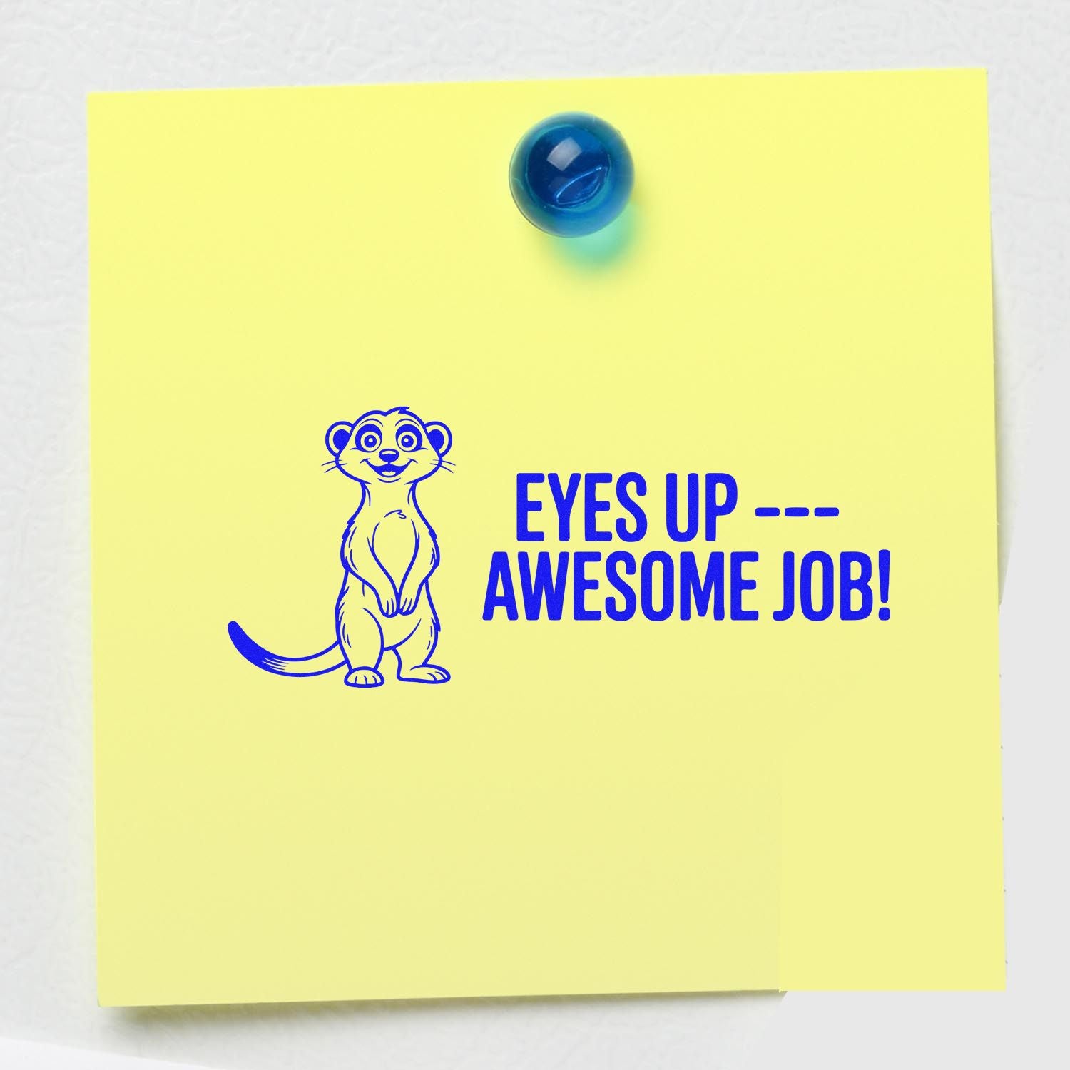 Yellow note with blue self-inking stamp seal of a smiling meerkat and EYES UP  AWESOME JOB!
