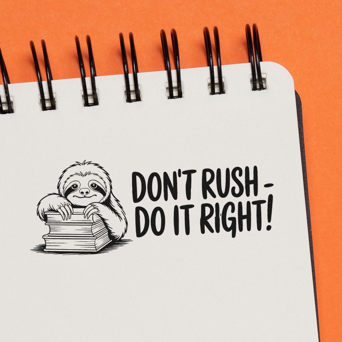Black stamp and seal design with sloth hugging books and text DONT RUSHDO IT RIGHT! on white page, orange background.