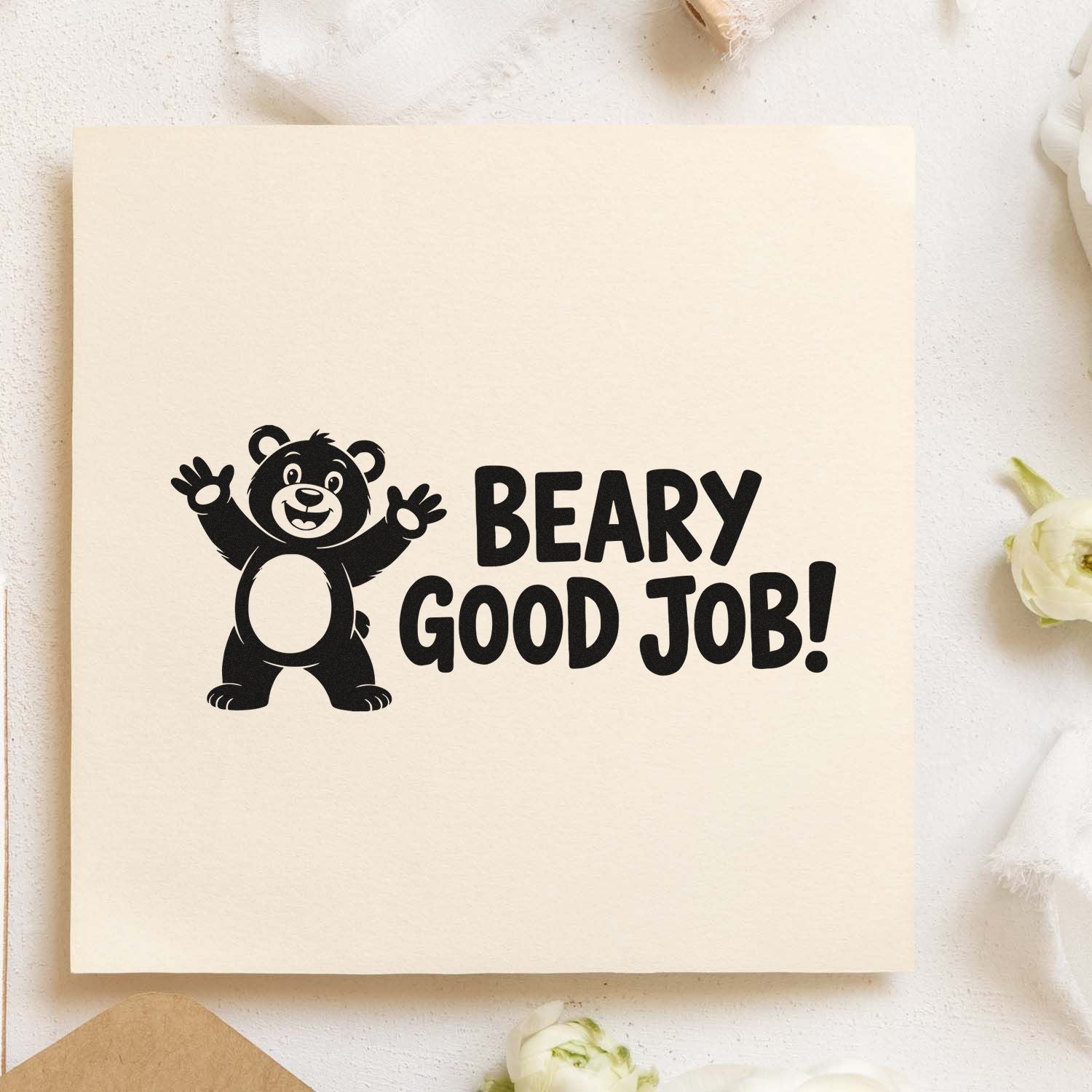 Black bear stamp seal with Beary Good Job! in bold black on cream paper.