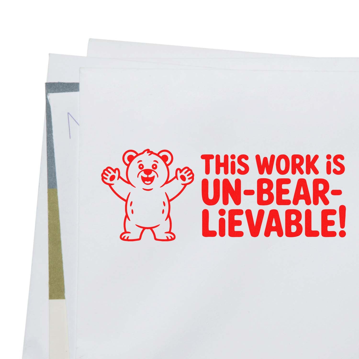 Red bear stamp and seal design with This work is un-bear-lievable! on stacked white paper.