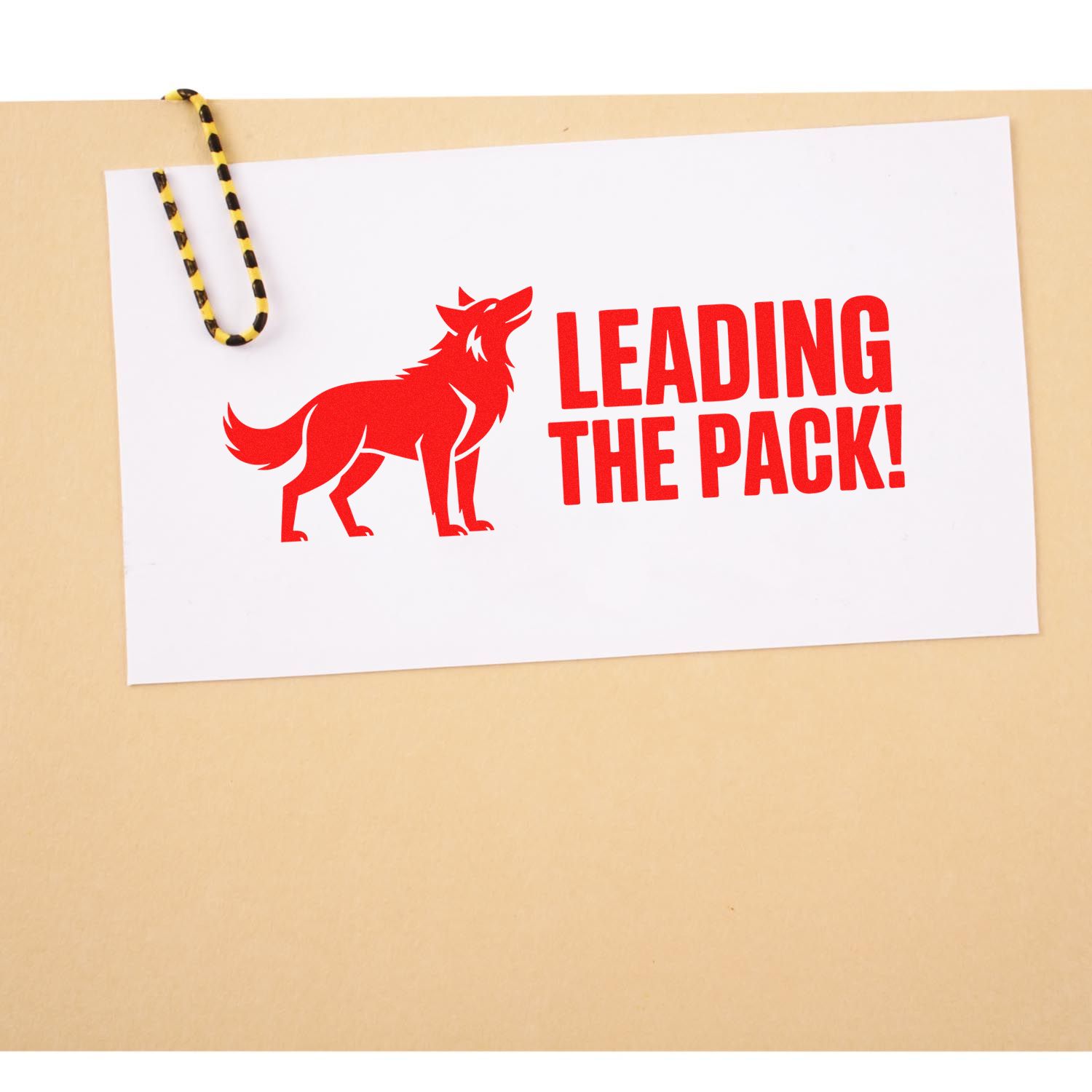 Red custom stamp and seal design with wolf and LEADING THE PACK! on white card, clipped with yellow-black paperclip.