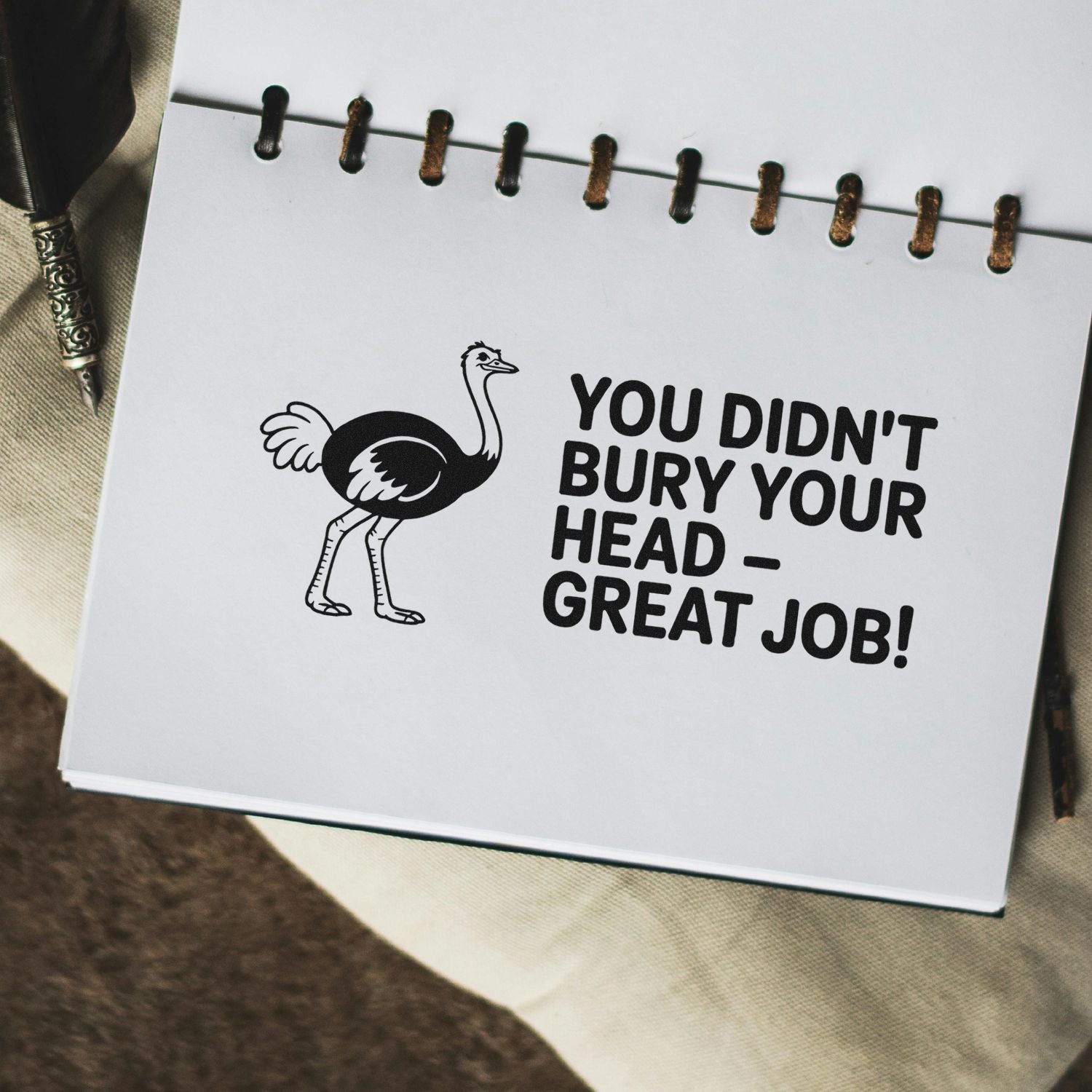 Black ostrich seal stamp on white notebook page with bold text: You didnt bury your head  great job!