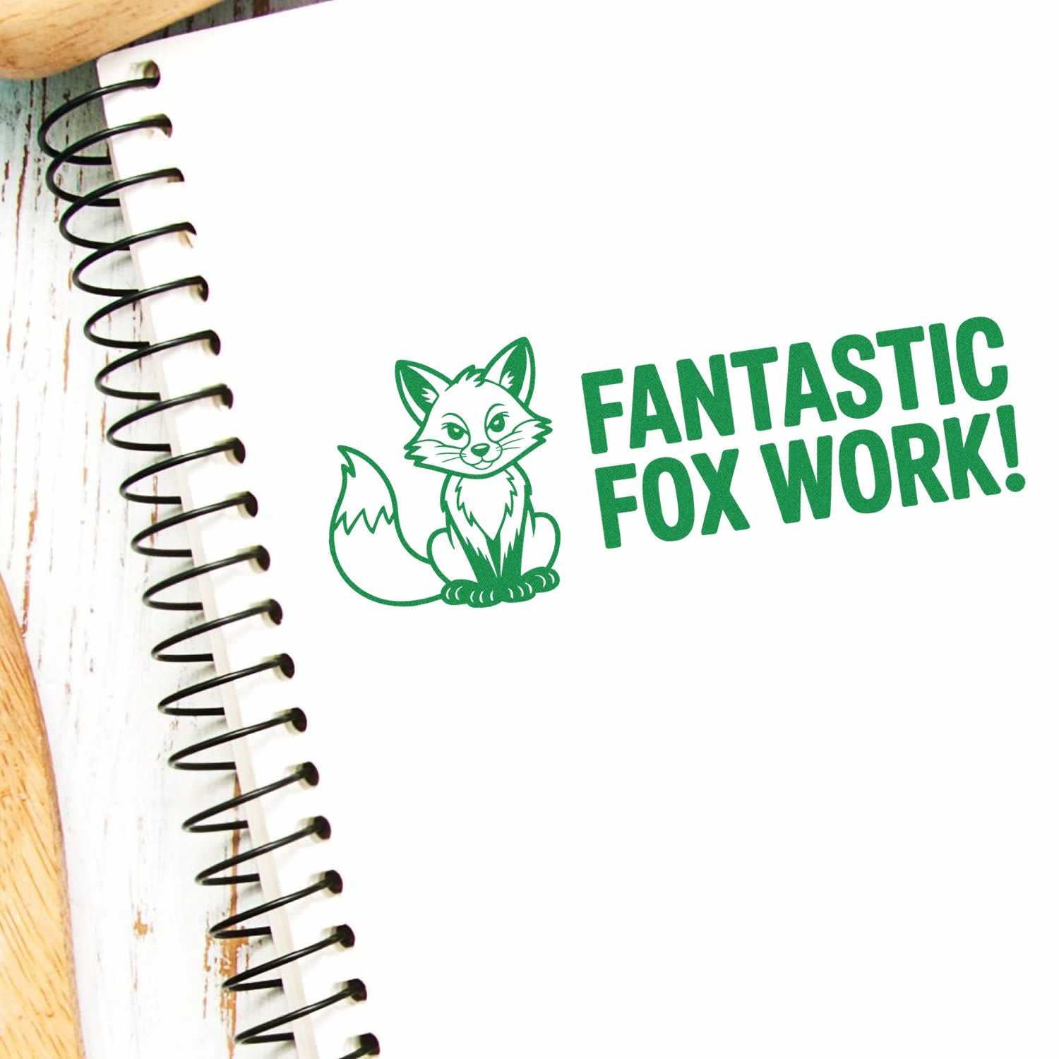 Green fox stamp seal with Fantastic Fox Work! on a white spiral notebook, in bold green ink