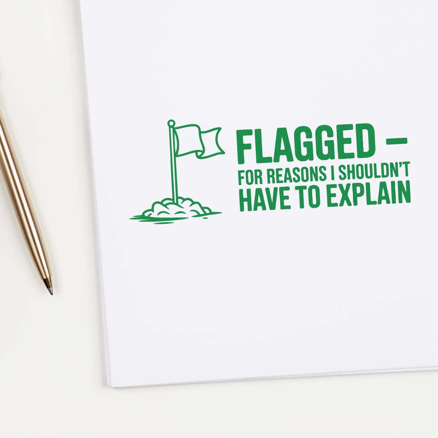 Green stamp seal reading FLAGGED FOR REASONS I SHOULDNT HAVE TO EXPLAIN with flag icon on white paper, gold pen