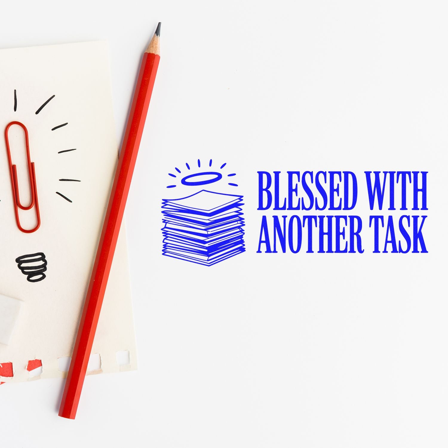 Blue stamp and seal reading Blessed with Another Task, with paper stack icon, beside red pencil and red paperclip.