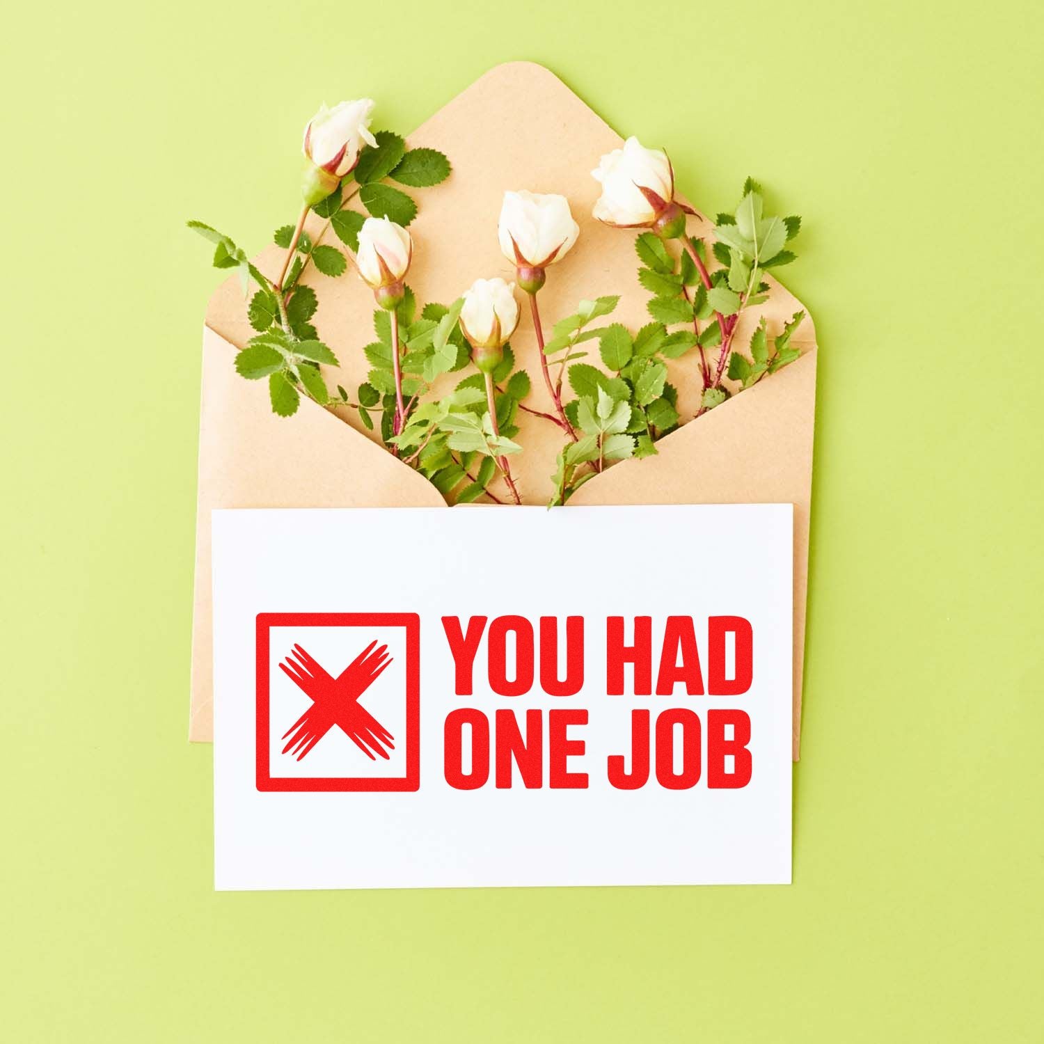 Brown envelope with white roses and red YOU HAD ONE JOB rubber stamp seal on a white card.