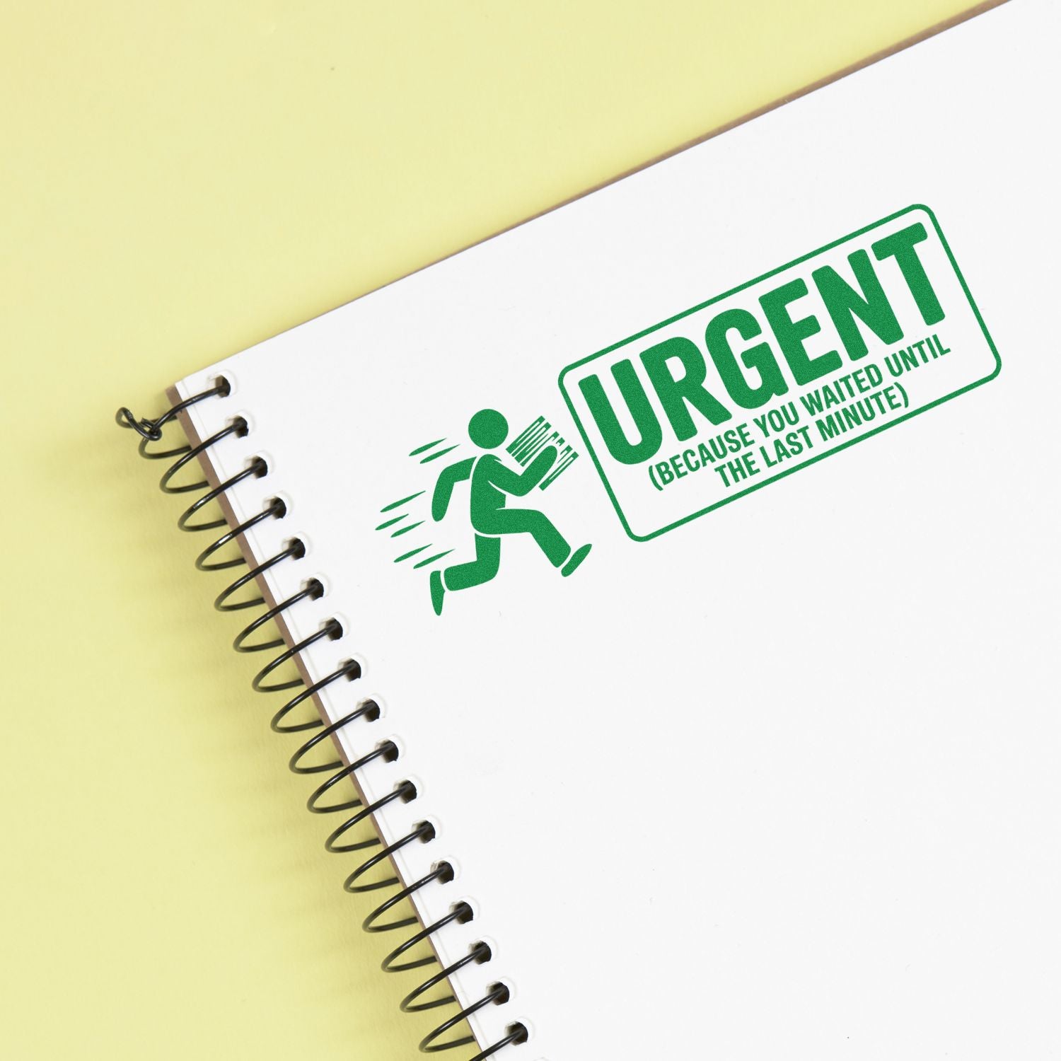 Green urgent rubber stamp seal on a white spiral notebook against a pale yellow background.