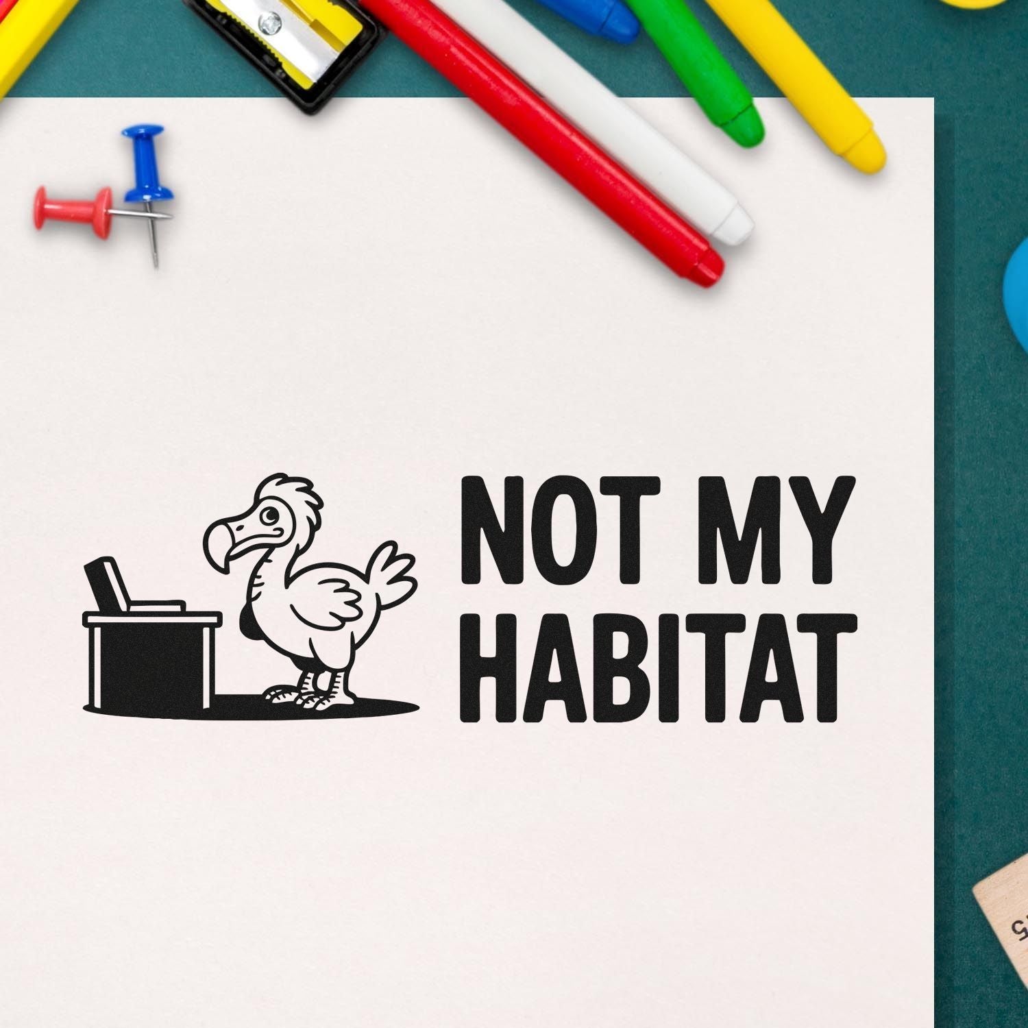 Black custom stamp and seal reading NOT MY HABITAT with dodo bird and trash can, on white paper with colorful markers.