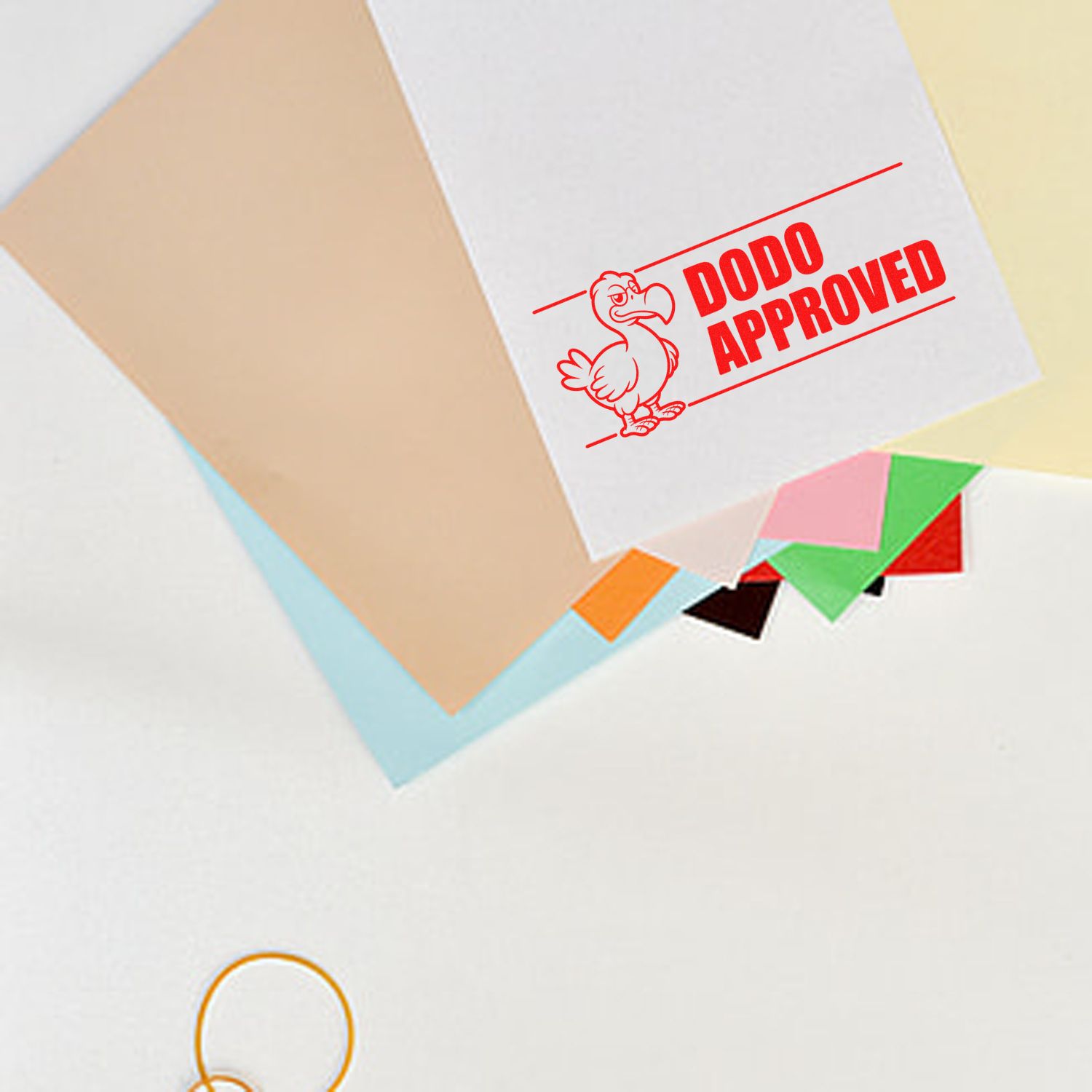 Red DODO APPROVED stamp seal on white paper with colorful tabs and pastel folders