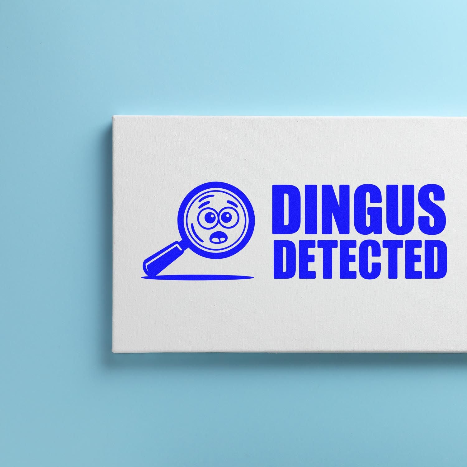White custom stamp and seal box with blue magnifying glass face logo and bold DINGUS DETECTED text on a light blue background.