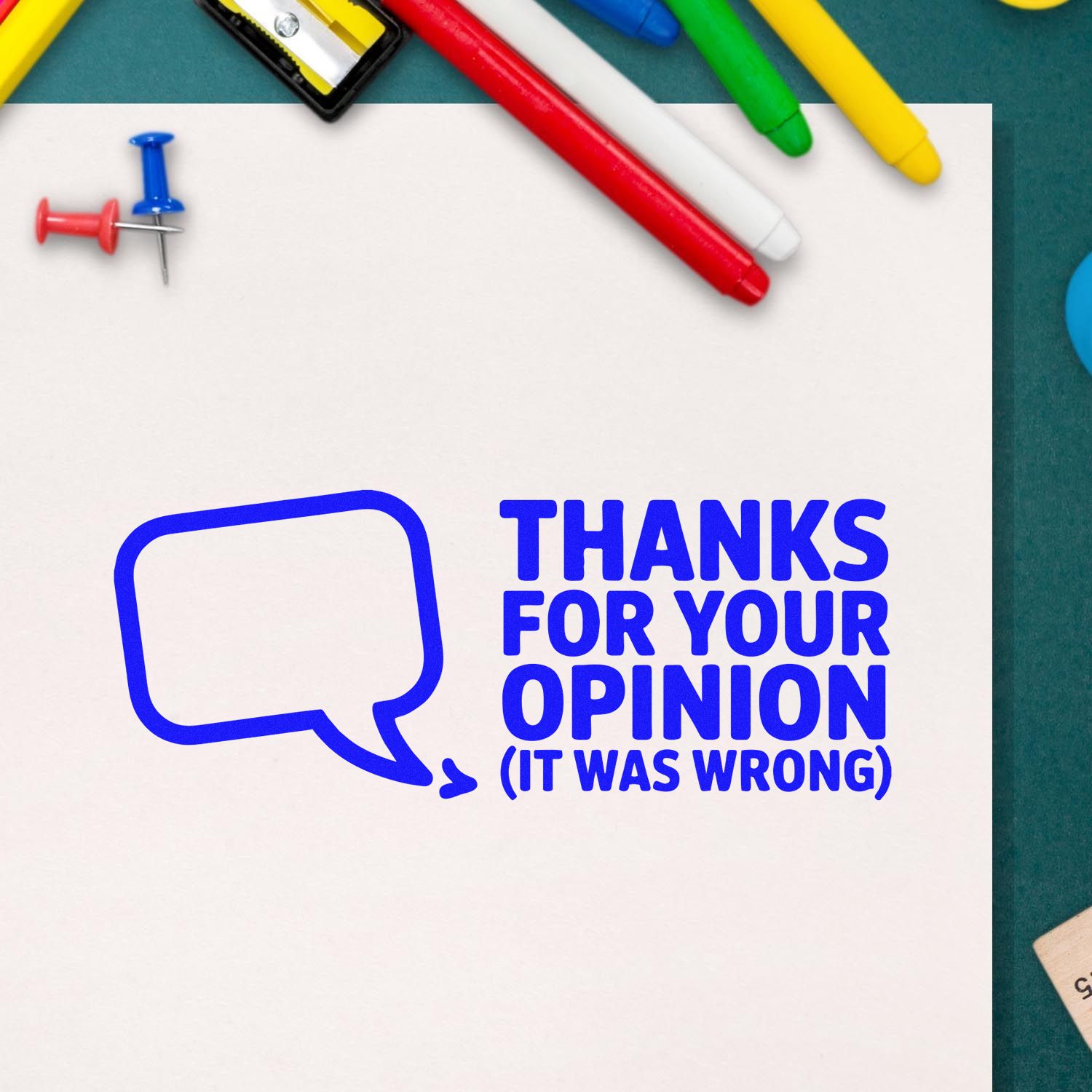 Blue stamp and seal design on white paper with speech bubble, colorful pens, and push pins; Thanks for your opinion (it was wrong).