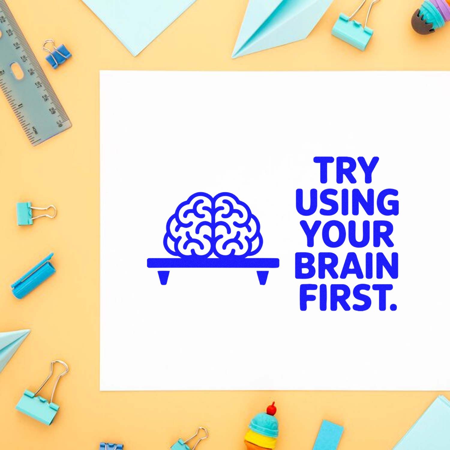 Blue brain stamp design with Try Using Your Brain First on white paper, framed by turquoise stamp and seal supplies.