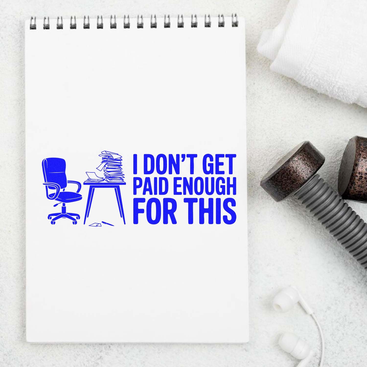 Blue stamp and seal design on white spiral notebook: chair, cluttered desk, and I DONT GET PAID ENOUGH FOR THIS text.