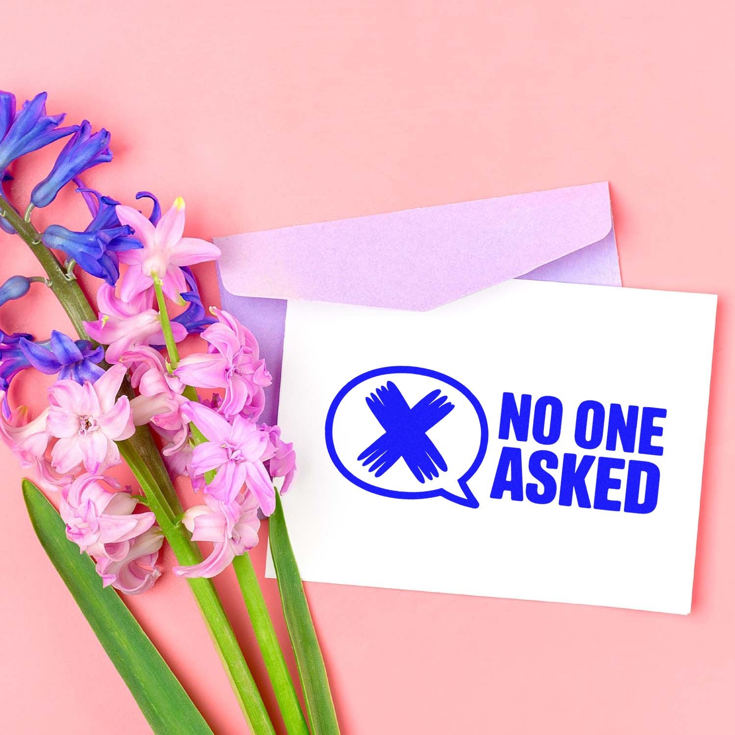 Blue No One Asked stamp and seal on white card, with lavender envelope and pink-purple flowers on a pink background.