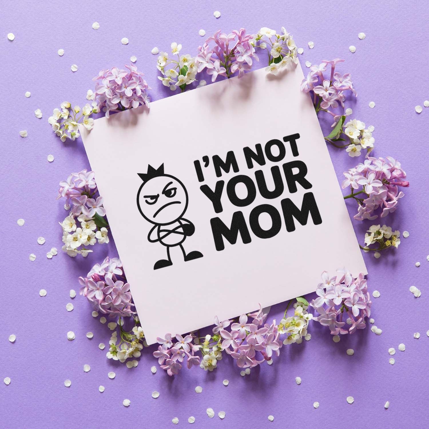 Custom rubber stamp seal reading IM NOT YOUR MOM in black on white, set on lavender with lilac flowers.