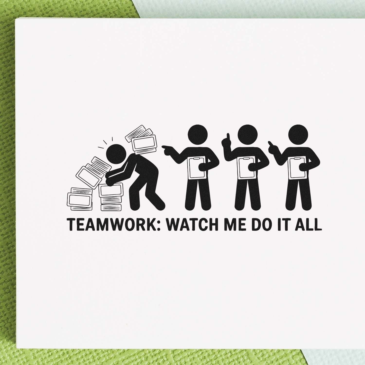 Black rubber stamp imprint of stick figures and TEAMWORK: WATCH ME DO IT ALL on white paper with green background.