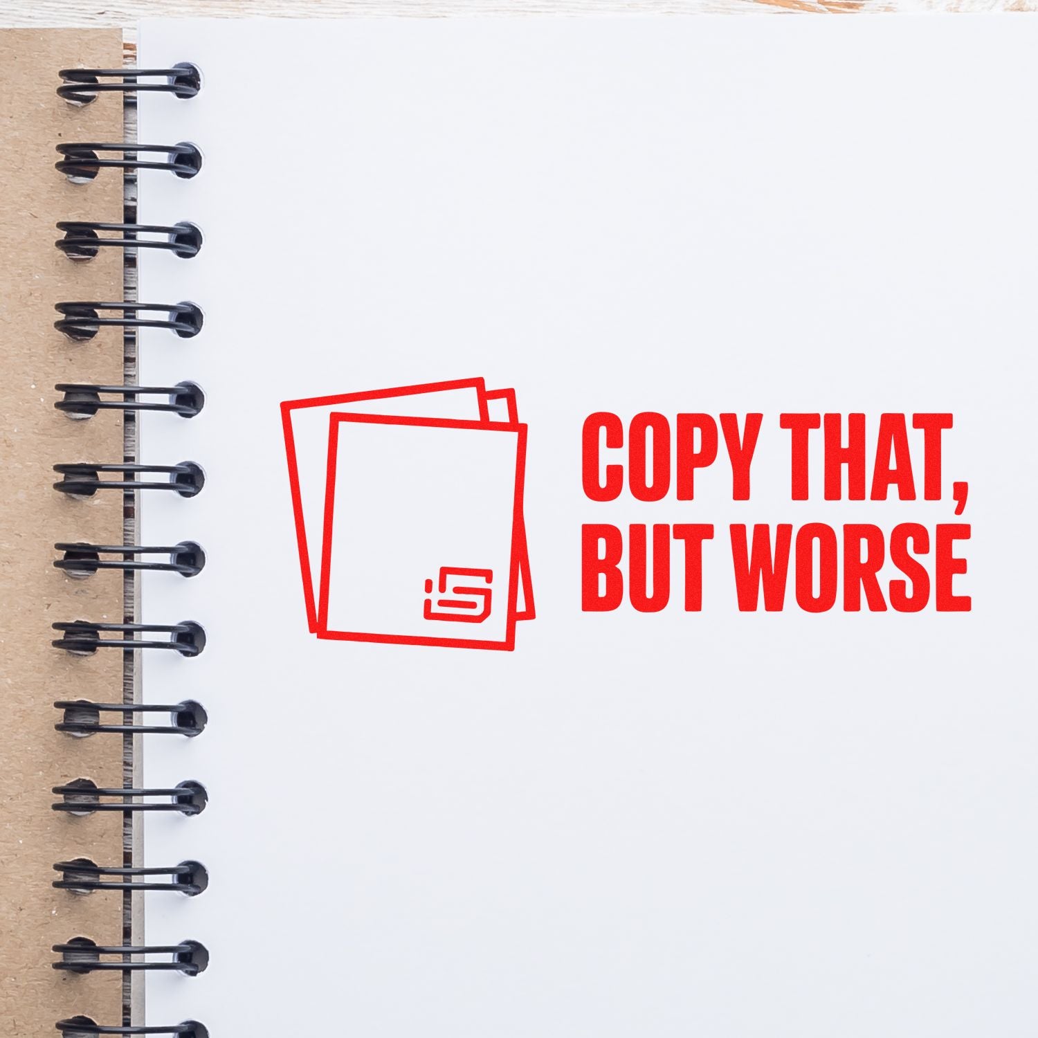 Red stamp-style seal logo and bold COPY THAT, BUT WORSE text on a white spiral notebook page.