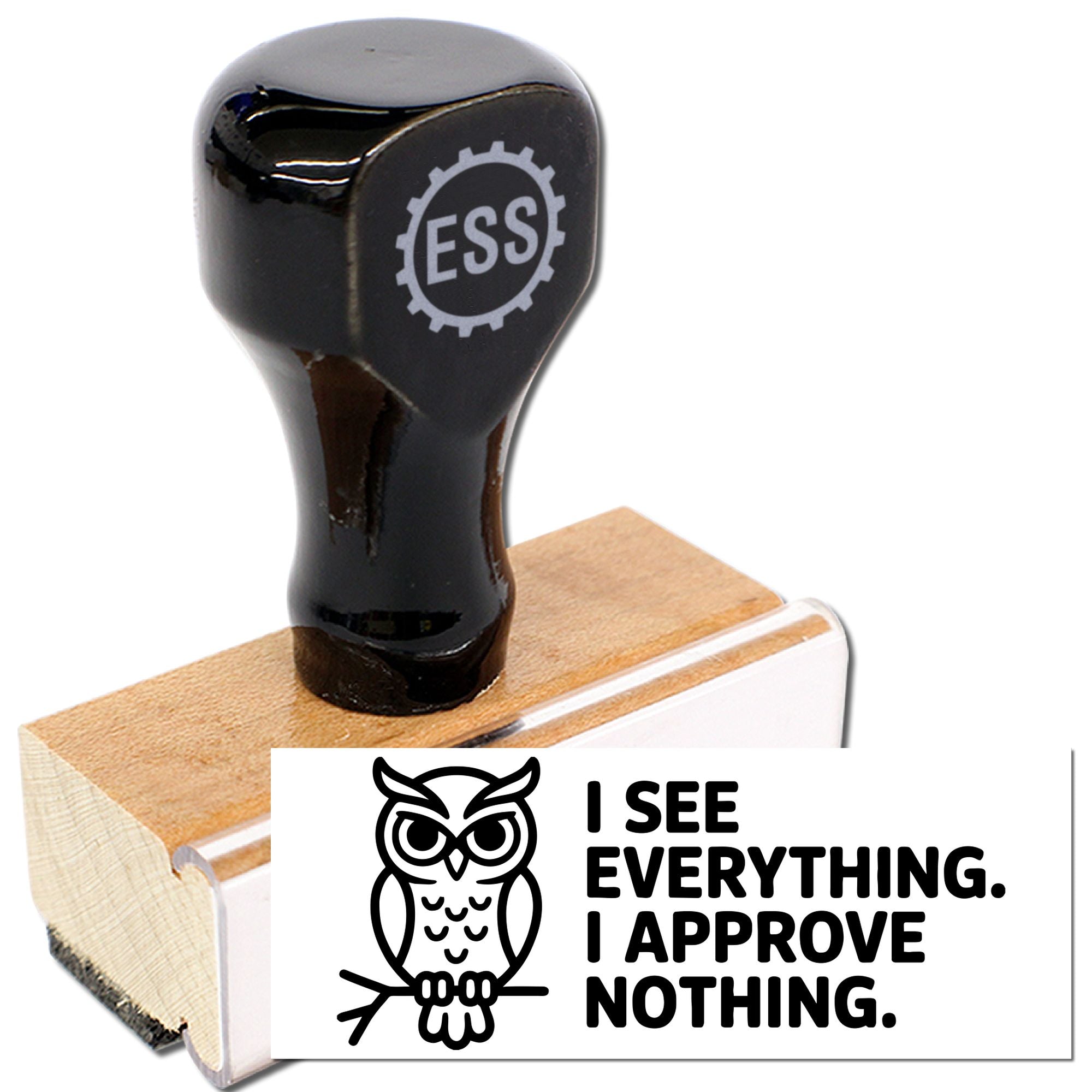 Black ESS rubber stamp on tan wooden handle, showing owl seal and bold white I see everything. I approve nothing. text.