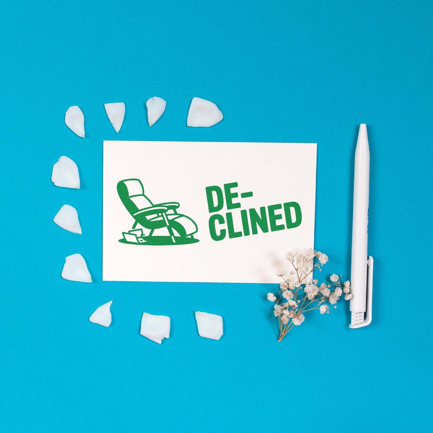 Green DECLINED stamp and seal on white card with chair icon, blue background, white pen, and scattered petals.