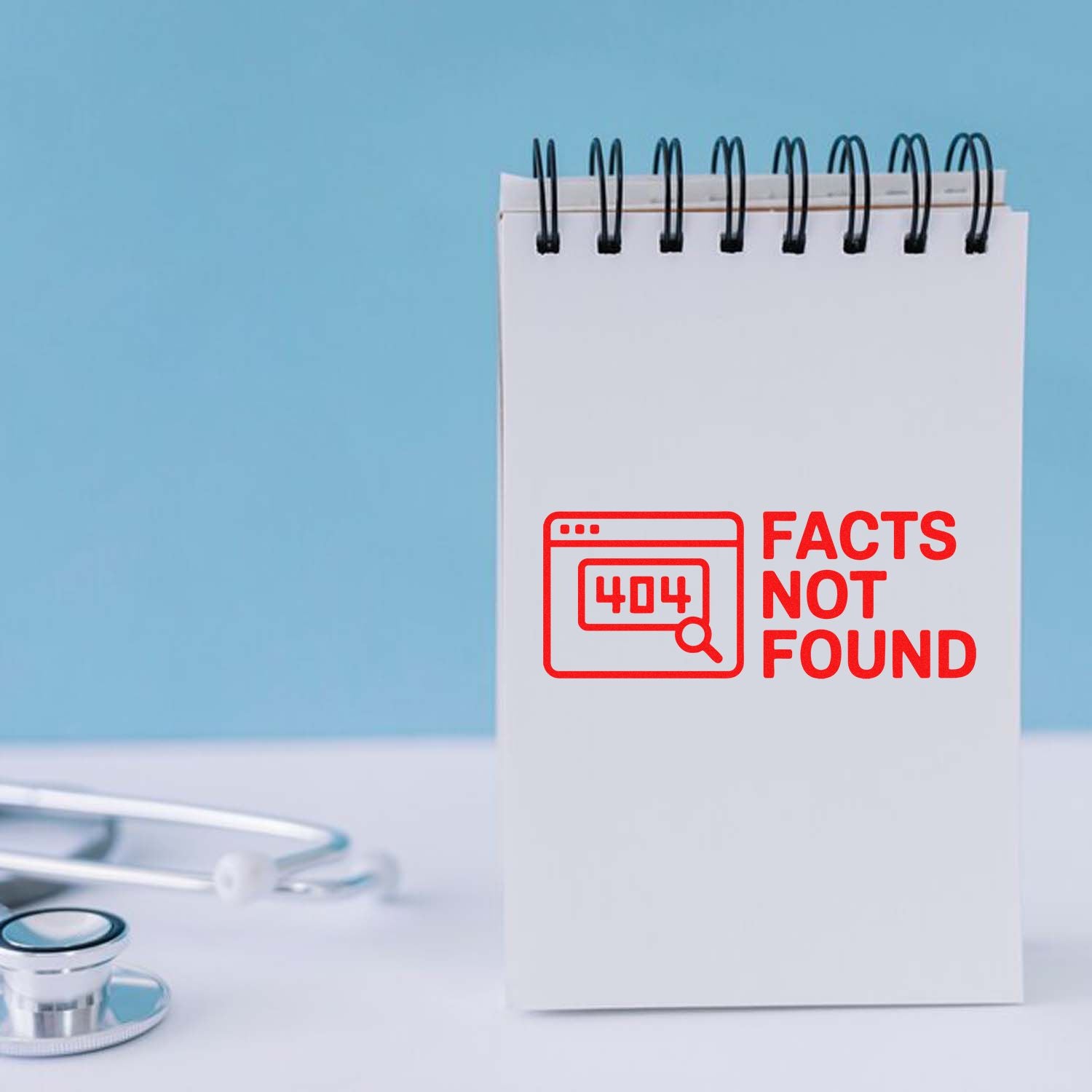 Red seal-style 404 Facts Not Found stamp on a white spiral notepad beside a stethoscope against a blue background.