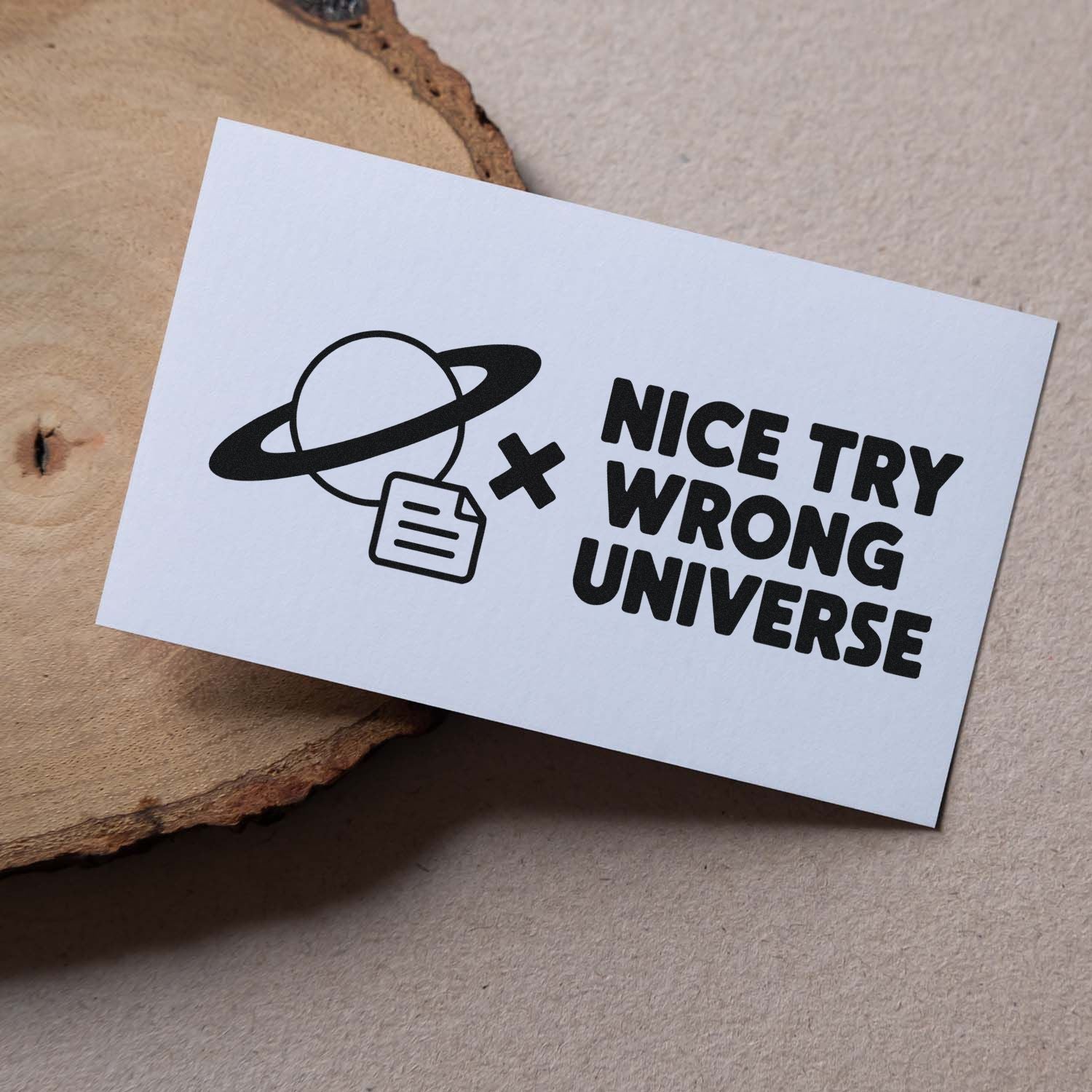 White stamp and seal card with black ringed-planet logo, document icon, and NICE TRY WRONG UNIVERSE on beige background.