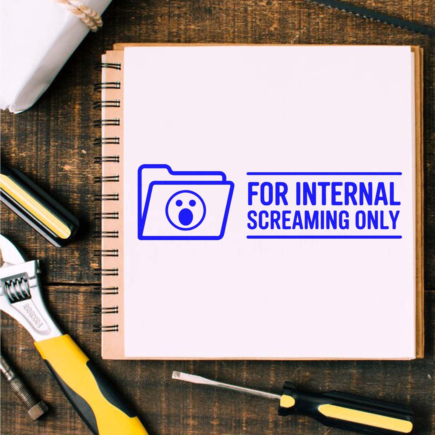 Blue stamp seal reading For Internal Screaming Only on a white notebook page, with folder icon and office tools.