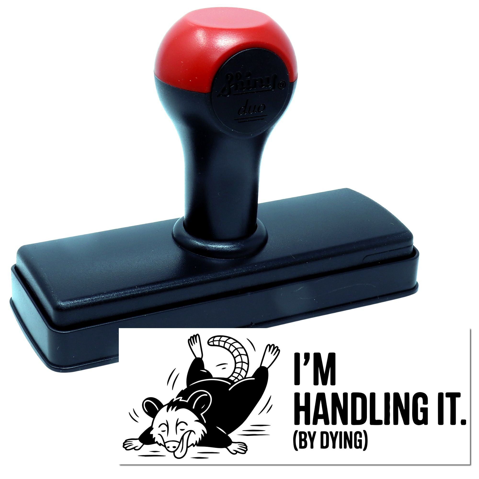 Red-and-black self-inking rubber stamp and seal with Im handling it (by dying) cartoon impression on white background.